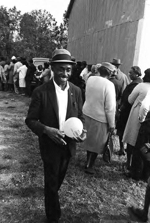 Hulett is holding a balloon that reads, “Vote Nov. 8 Lowndes County Freedom Organization.” 1966. By Jim Peppler.