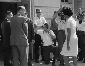 Vivian Malone entering Foster Auditorium through a crowd that includes photographers, National Guard members, and the Deputy U.S. Attorney General. Credit: Library of Congress.