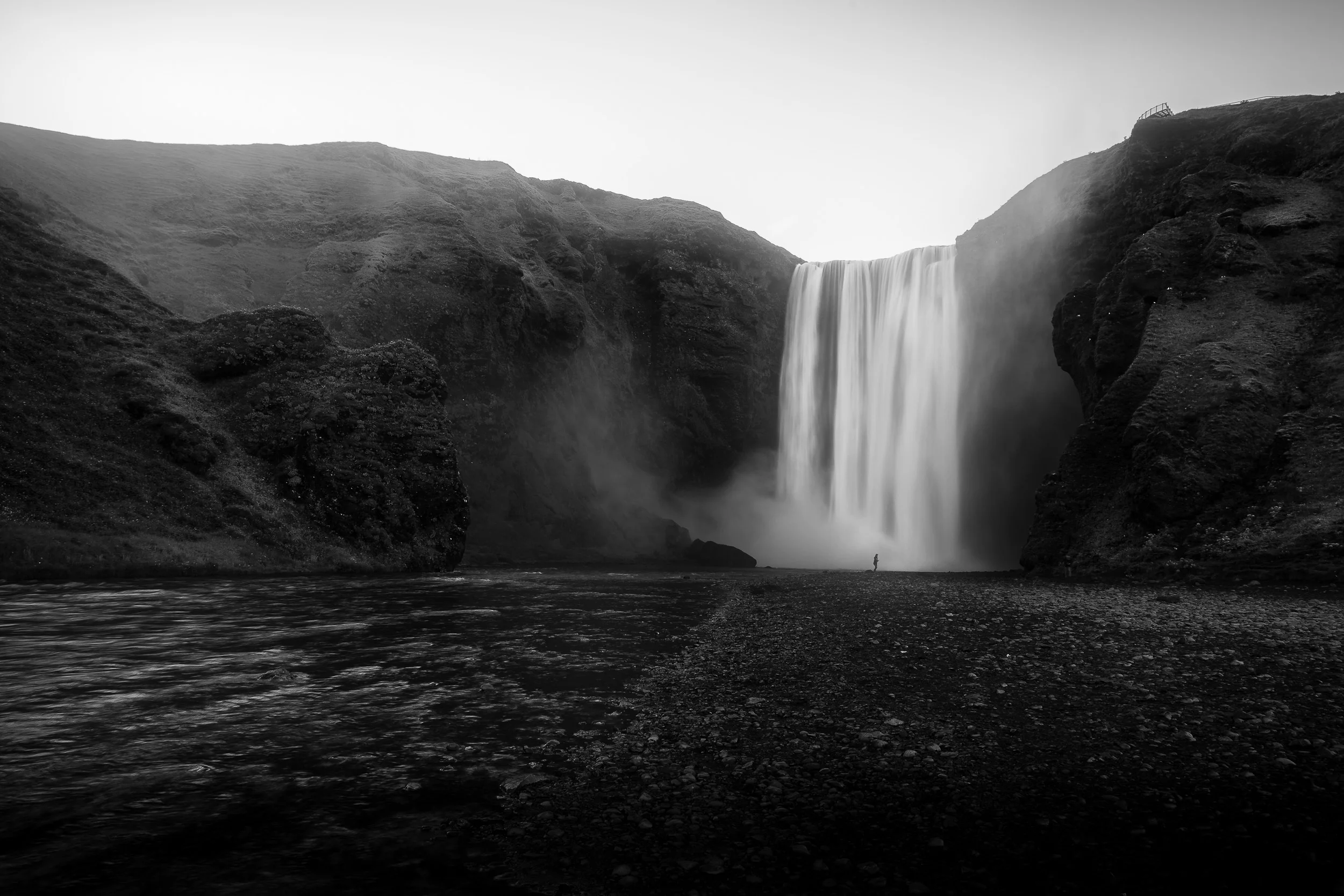 Silhouette of a person standing in front of Skogafoss waterfall in Iceland