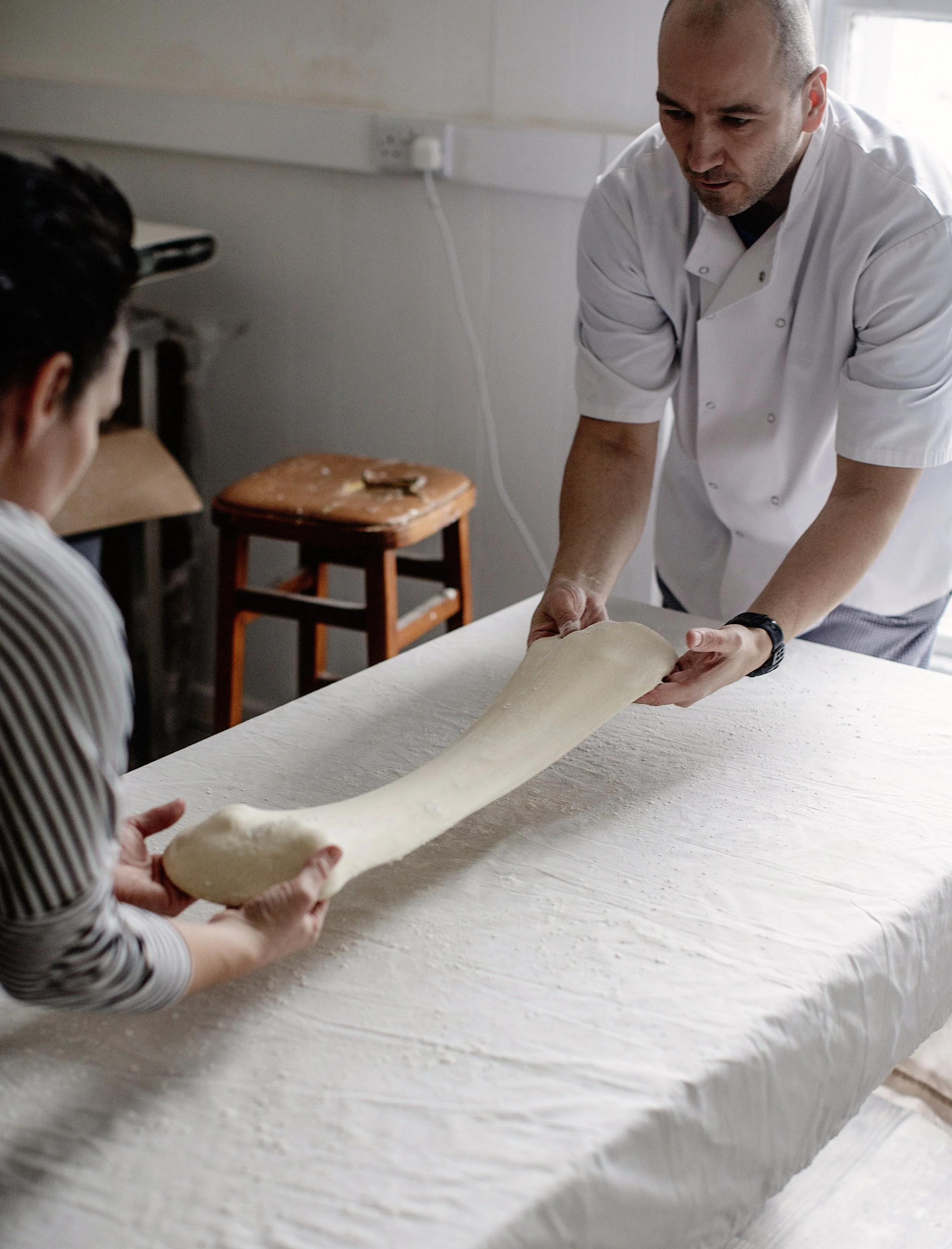 Stretching the dough is a two-person job.