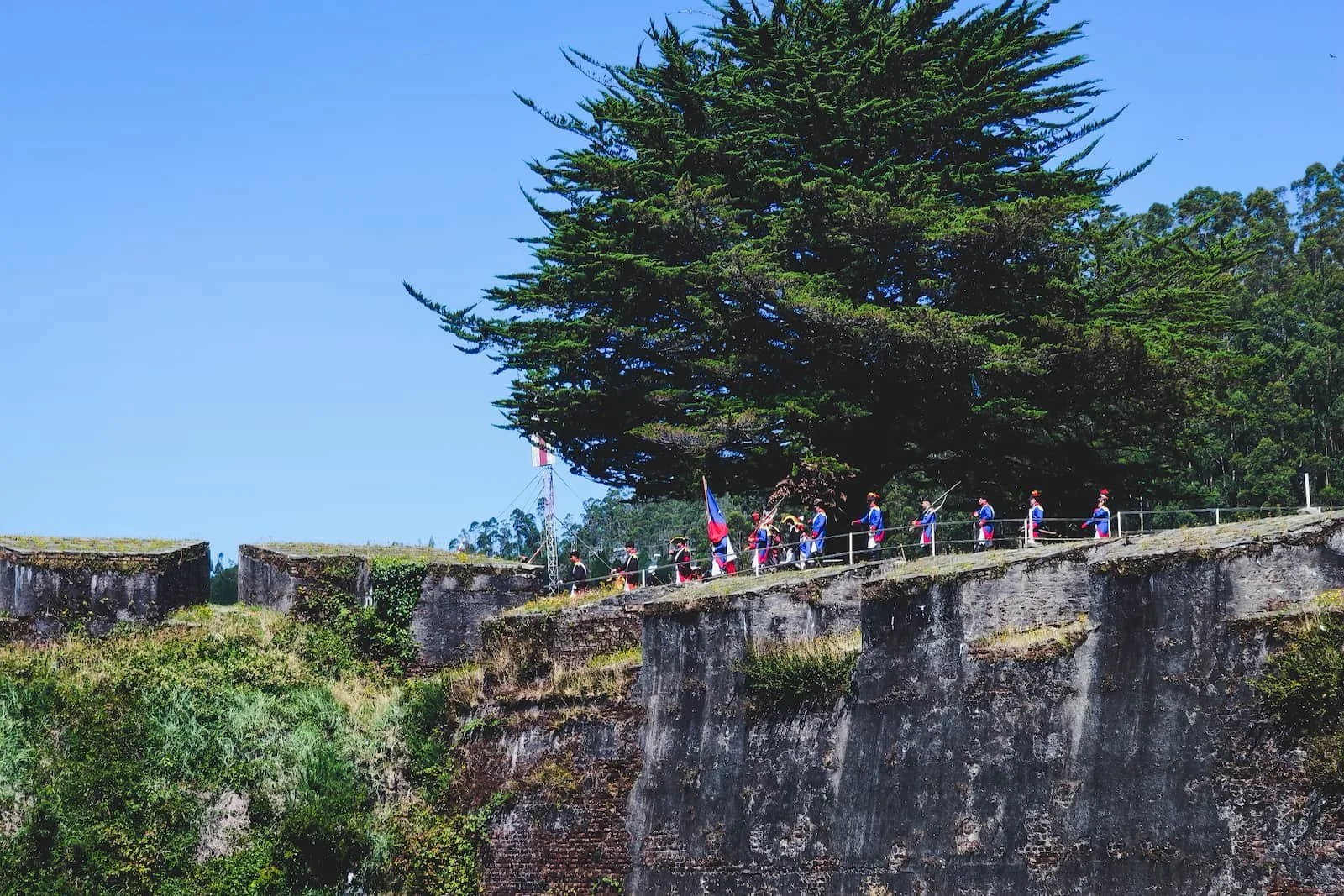 Historical reenactment with actors in period dress at Castillo San Sebastián in Corral.