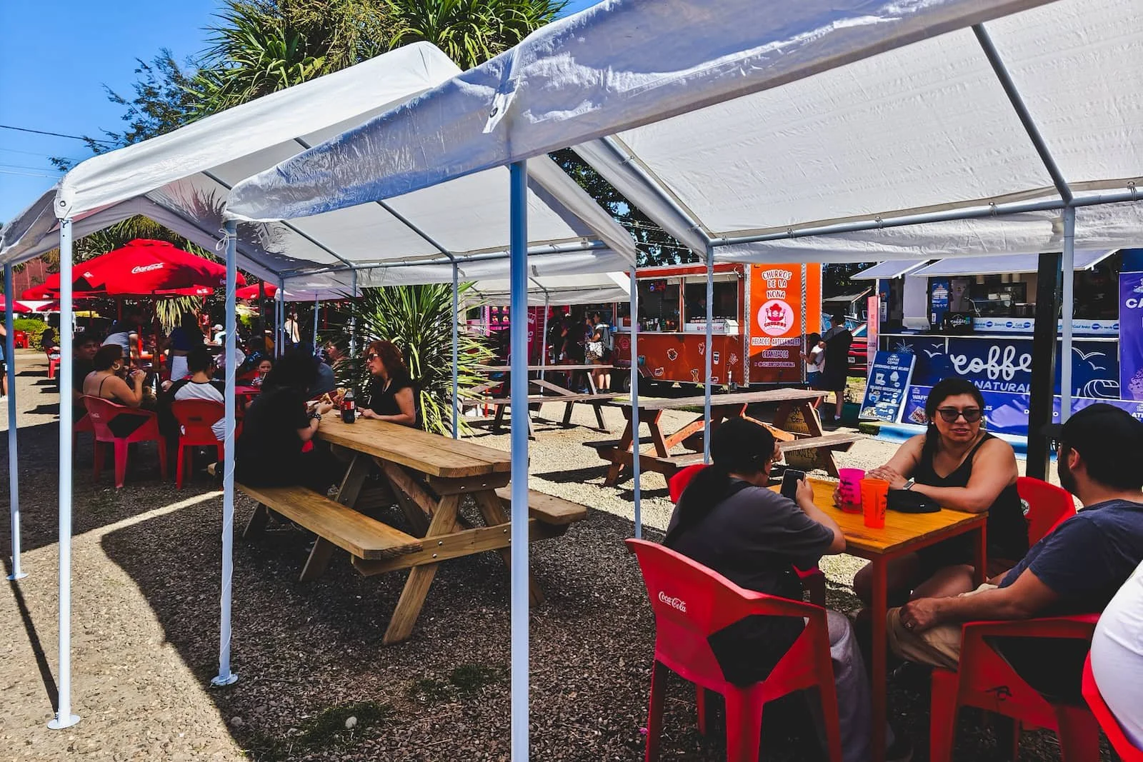 Outdoor festival at the Parque Saval event center in Valdivia, Chile, with craft stalls, beer stands, and a live music stage.