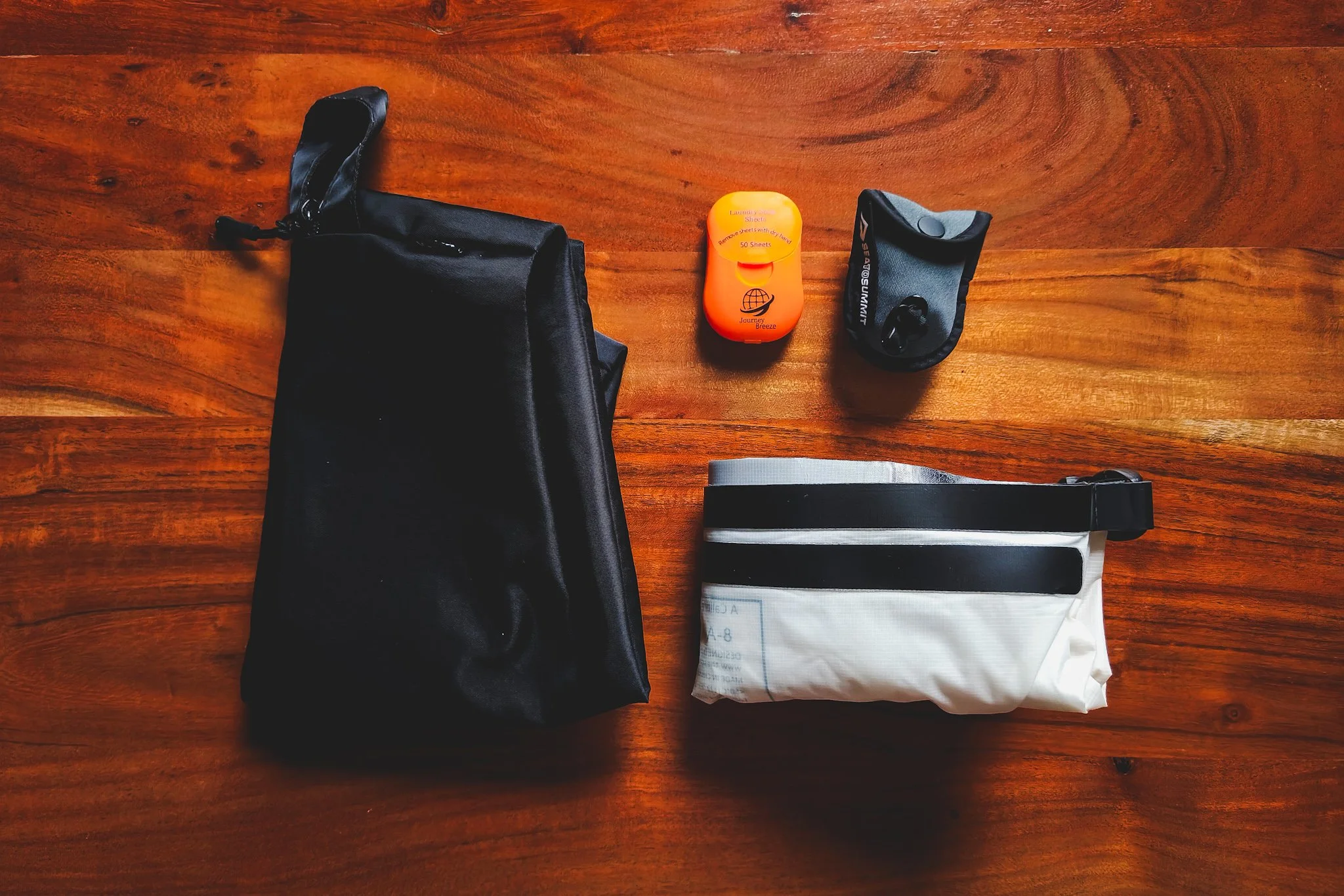 Flat lay of laundry system: laundry bag, detergent sheets, clothesline, and wash bag.