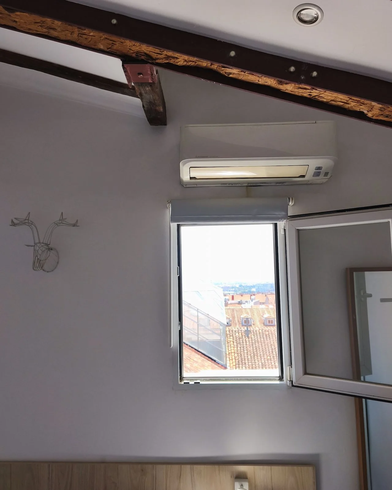 Bright attic apartment in Madrid with natural light coming through the window.