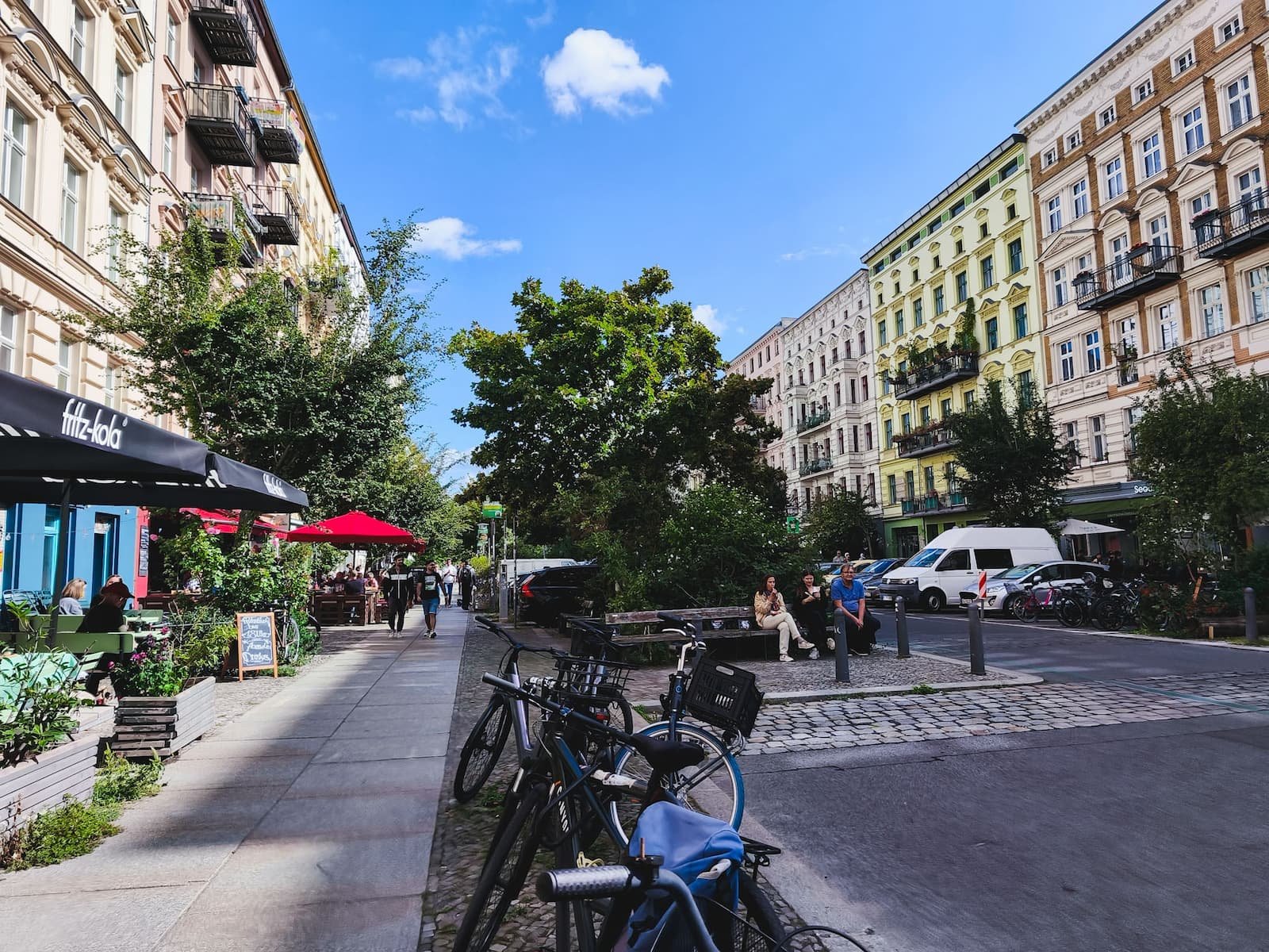 Oderberger Straße  in Berlin's Prenzlauer Berg neighborhood, with historic apartment buildings and outdoor cafés.