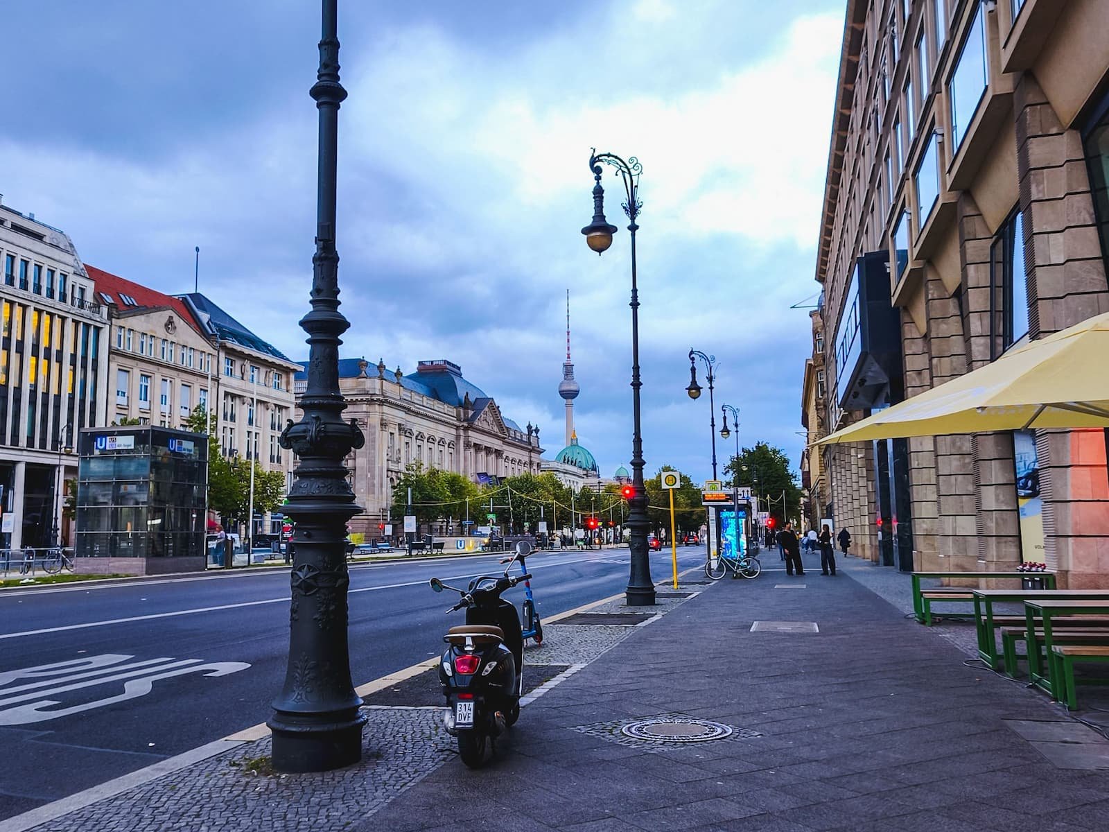 Unter den Linden boulevard in central Berlin, lined with historic buildings and decorative street lamps.