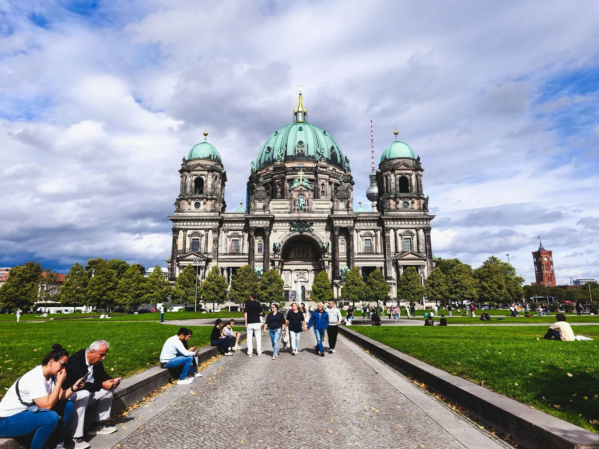 Berlin Cathedral with its green domes, viewed across the lawn and walkway of the Lustgarten.