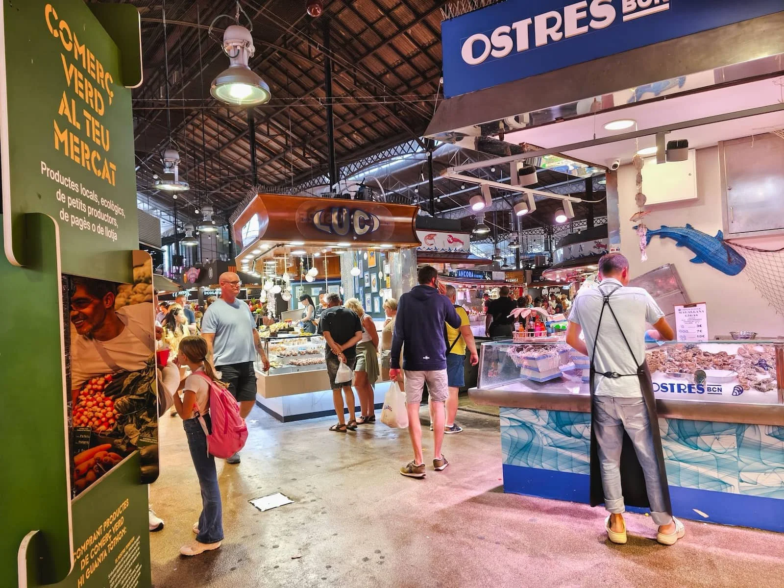 Shoppers and food stalls inside La Boqueria market in Barcelona