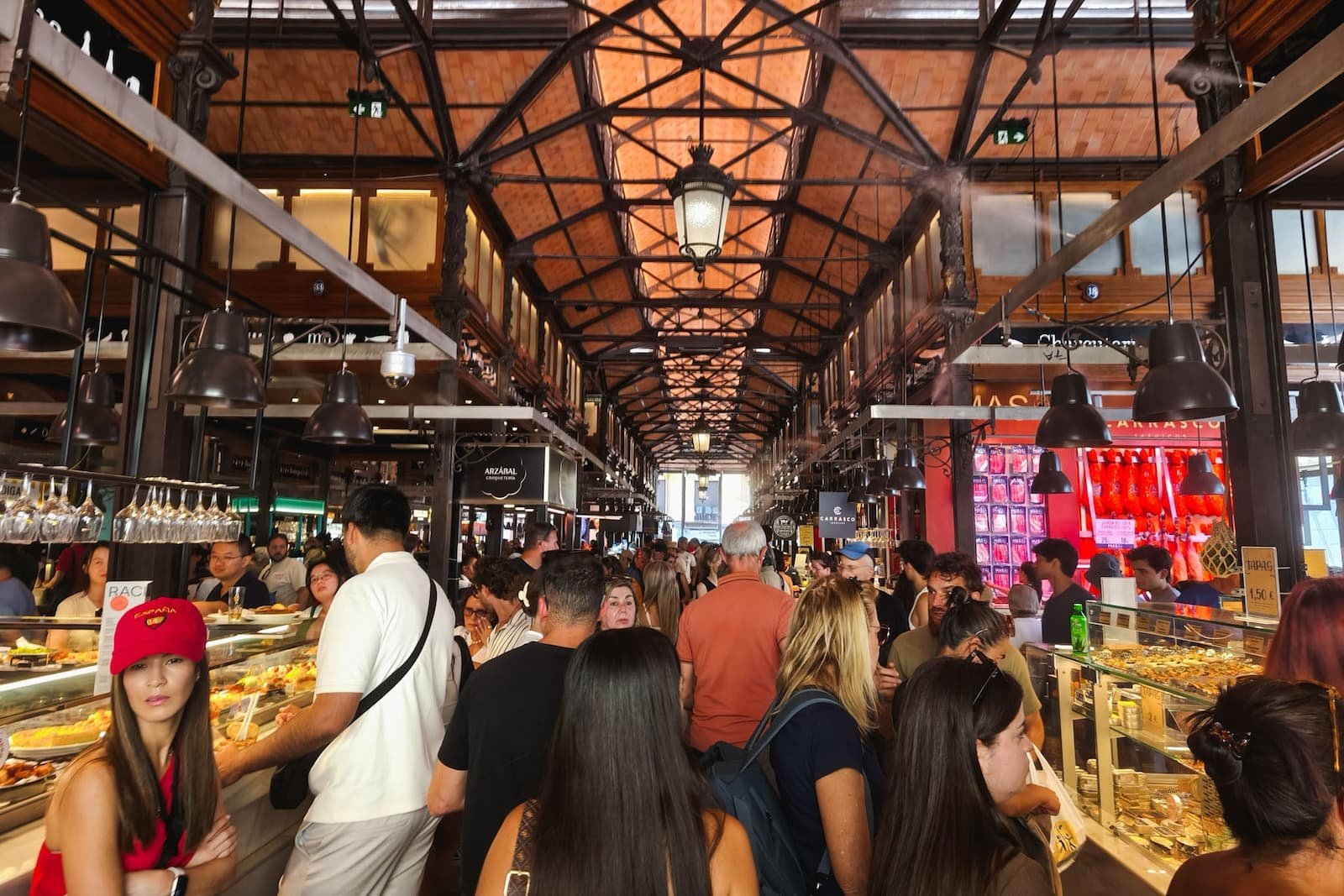 Crowded interior of Mercado de San Miguel, a historic food market near Plaza Mayor in Madrid.