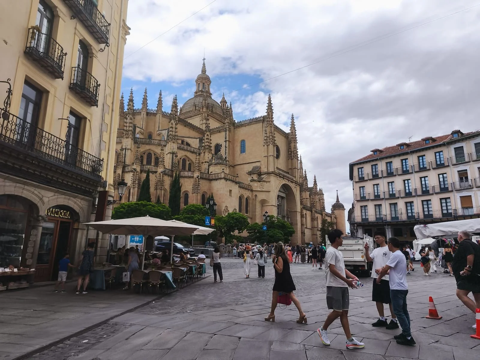 Segovia Cathedral rising above Plaza Mayor with people walking through the square.