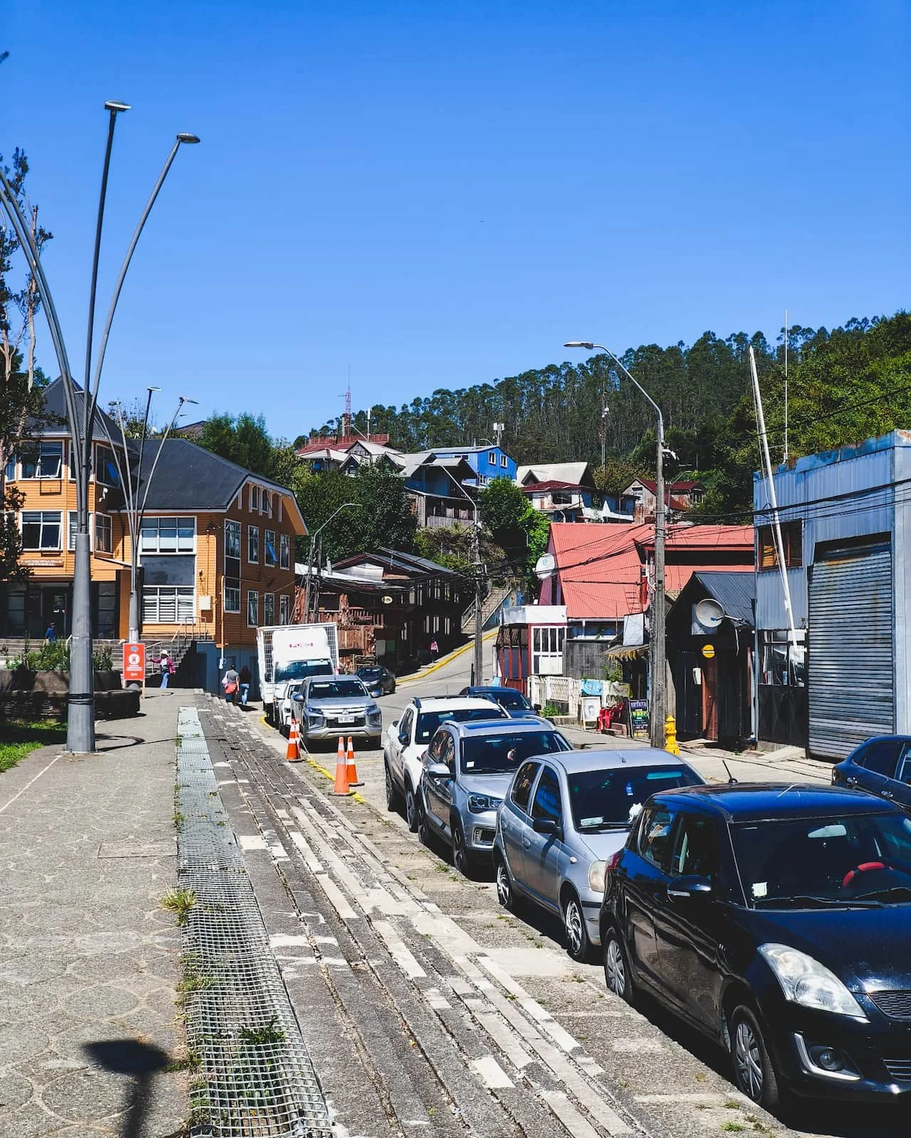 Street in Corral with houses as the hillside begins to slope upward near the harbor.