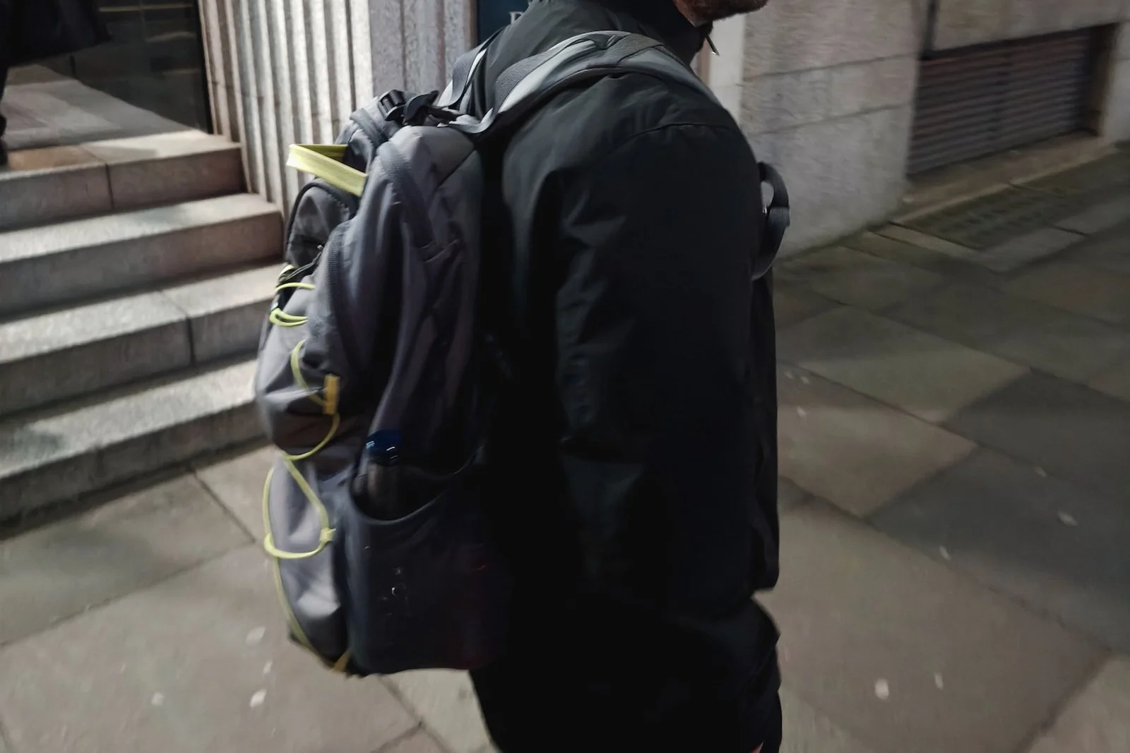 Person walking in a city carrying a small backpack used for one-bag travel.