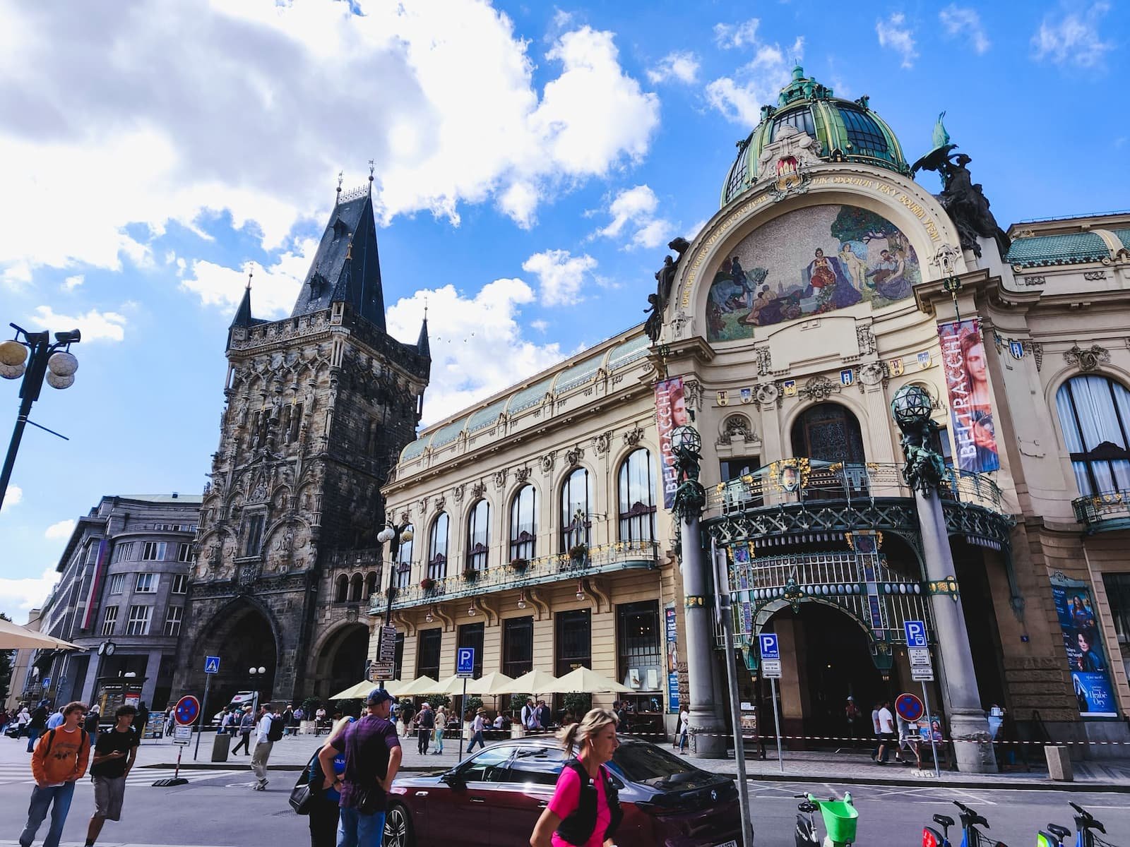 Gothic Powder Tower standing beside the ornate Art Nouveau Municipal House in Prague.
