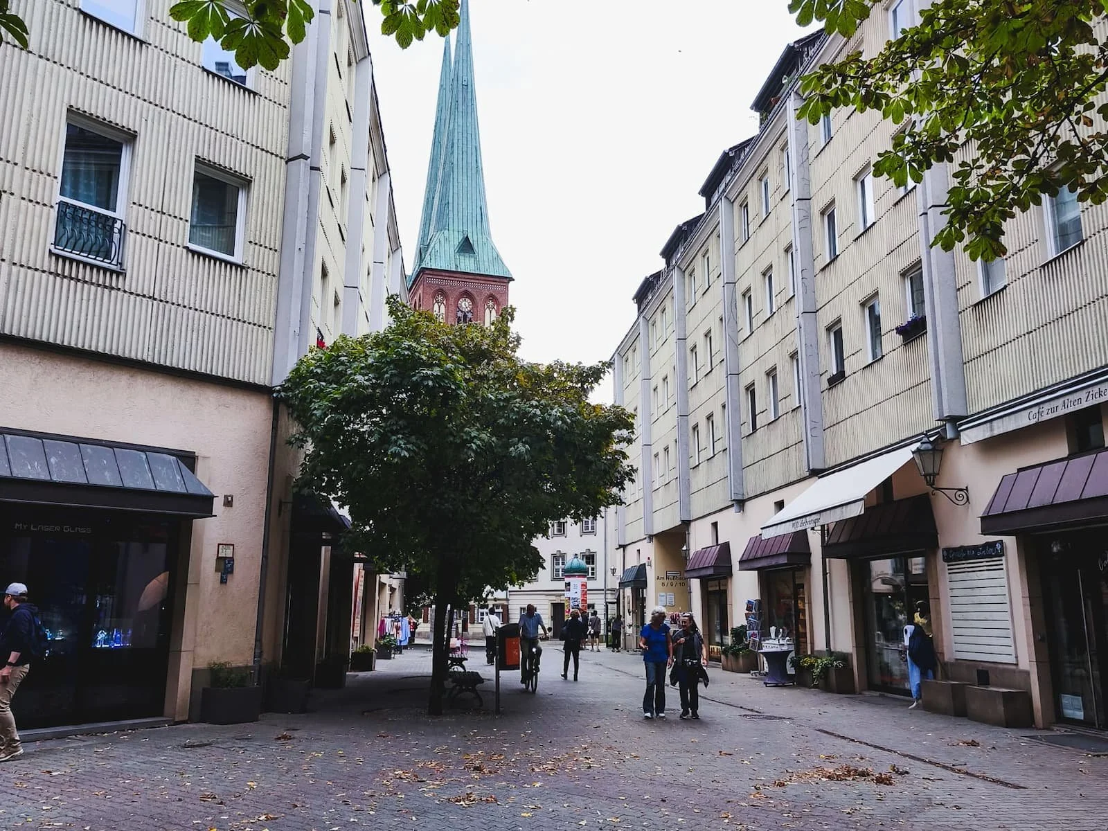 Quiet pedestrian street in Berlin's Nikolaiviertel, with traditional-looking buildings and a church spire.