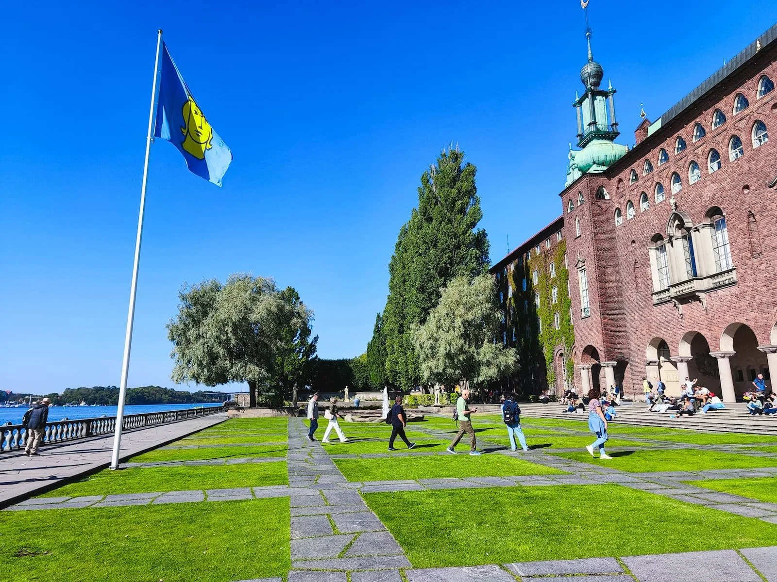 Waterfront lawn and brick facade beside Stockholm City Hall