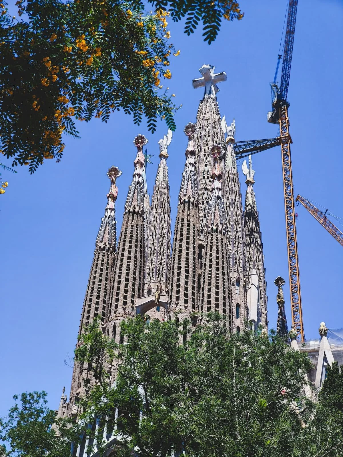 Towers and ornate exterior of the Sagrada Família against a blue sky