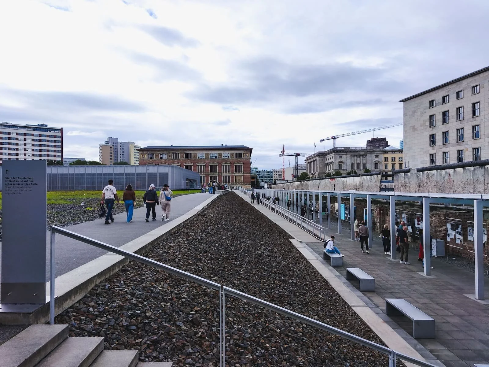 Outdoor exhibition at the Topography of Terror documentation center, with a gravel-lined trench and information panels.