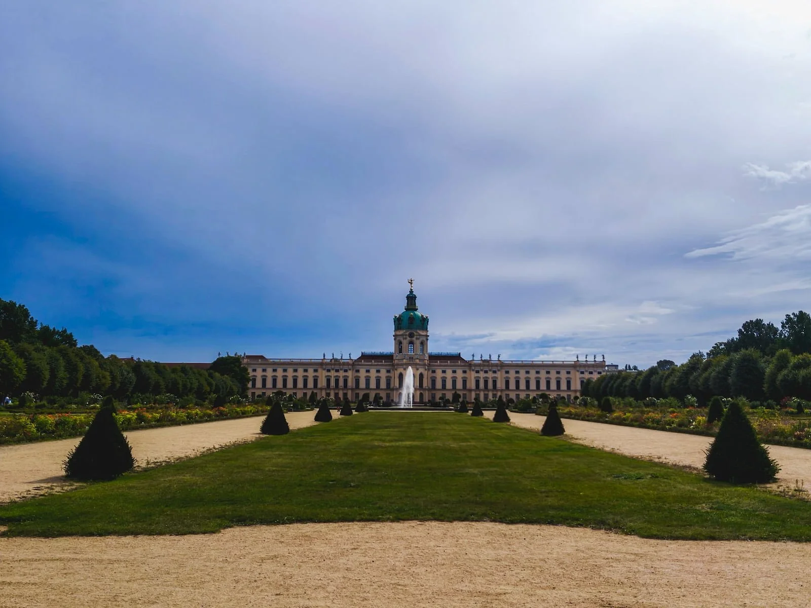 Charlottenburg Palace viewed from its formal gardens, with pathways, lawns, and trimmed hedges.