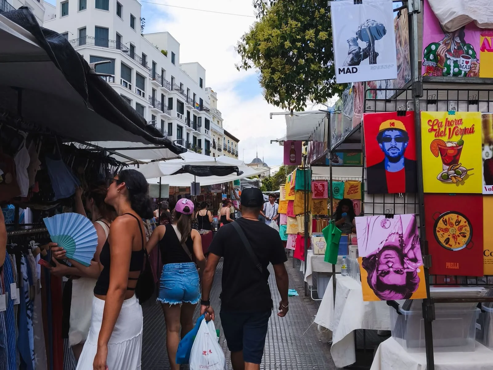 Crowded street stalls and shoppers at El Rastro flea market in Madrid