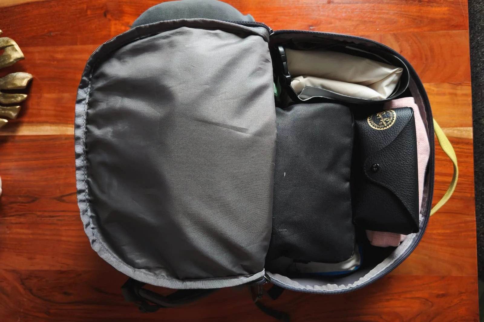Open backpack showing a complete one-bag travel setup with organized items.