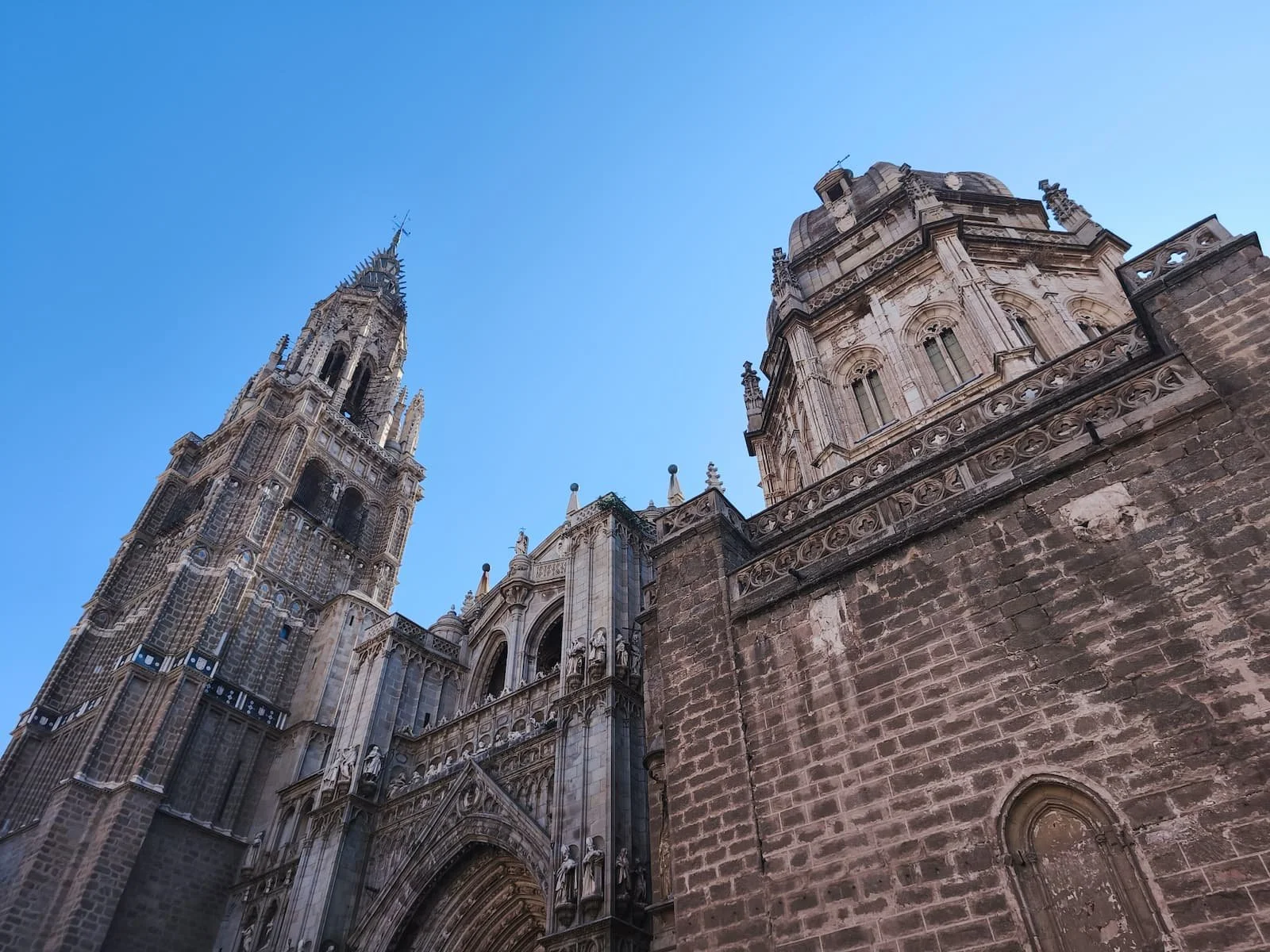 Gothic exterior of Toledo Cathedral beneath a blue sky