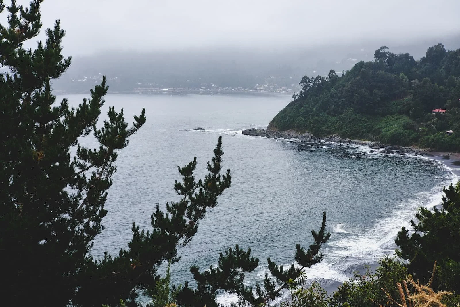 Foggy coastline seen from a road in Niebla town.