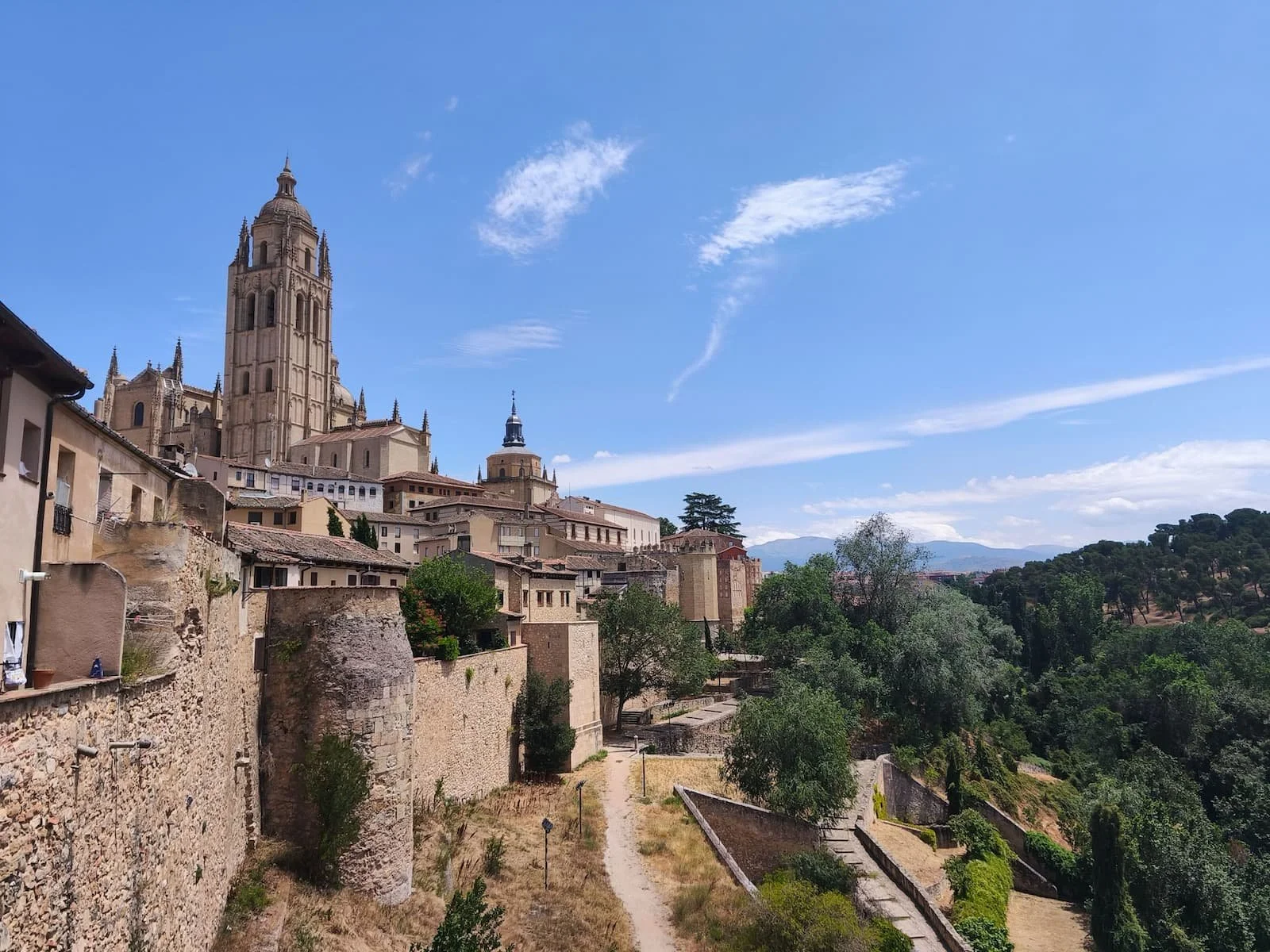 View of Segovia Cathedral and the old city walls from the scenic route toward the Alcázar.