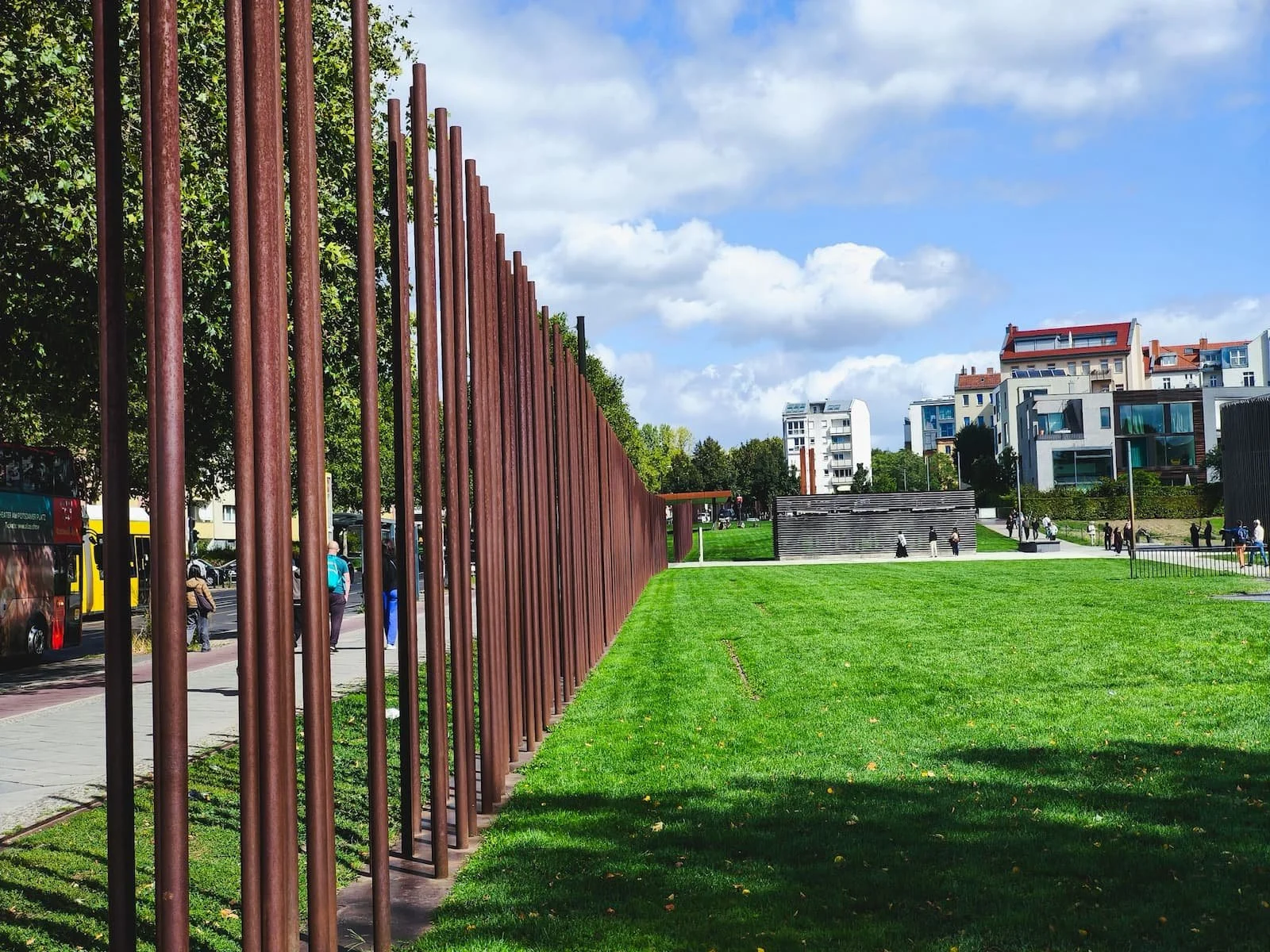 Preserved section of the Berlin Wall Memorial along Bernauer Straße, with rows of tall metal poles.