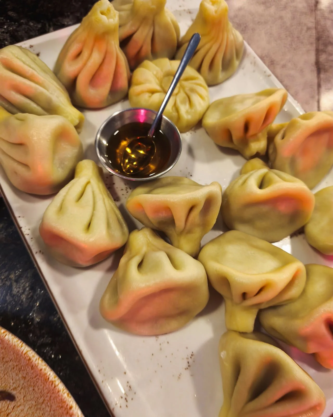 Plate of Georgian khinkali served with sauce at Café Daphna in Tbilisi