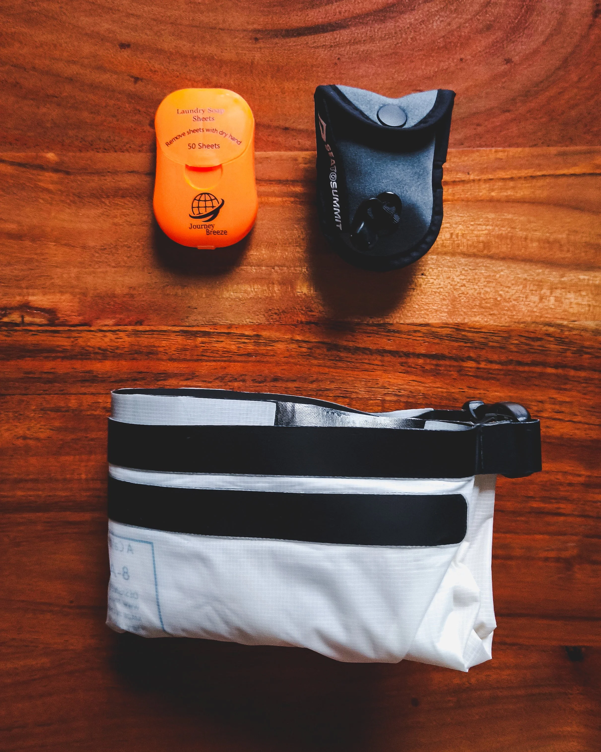 Flat lay of detergent sheets, packed clothesline, and folded wash bag.