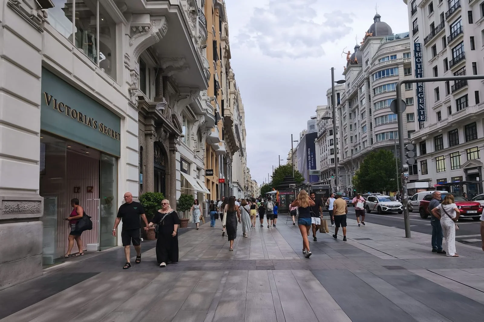 Wide view of Gran Vía in Madrid with historic buildings and people walking.