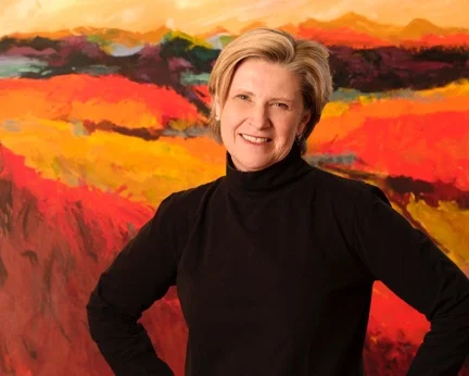 An image of Cincinnati artist Trish Weeks standing in front of her abstract painting.
