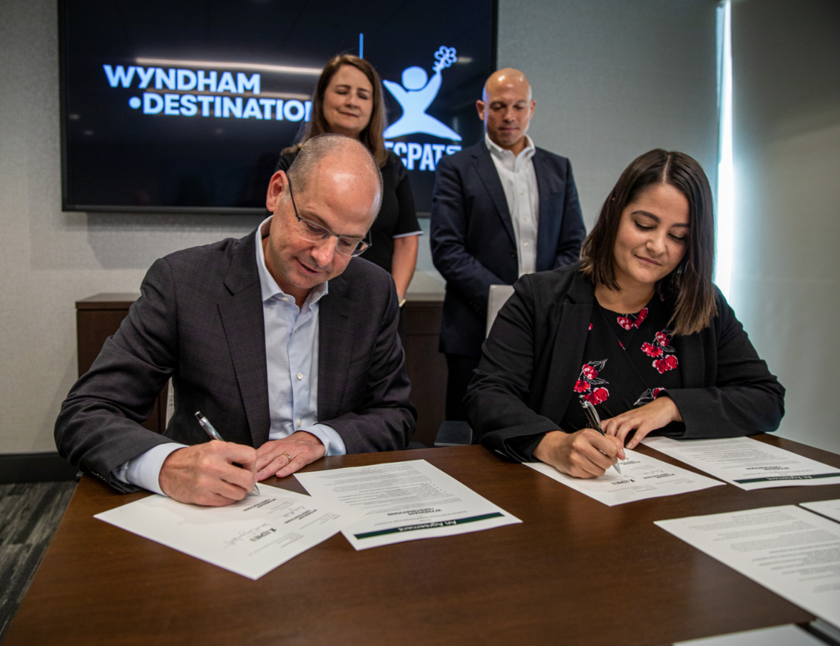 Michael D. Brown President & Chief Executive Officer (CEO) for Wyndham Destinations, left, and Michelle Guelbart sign The Code.