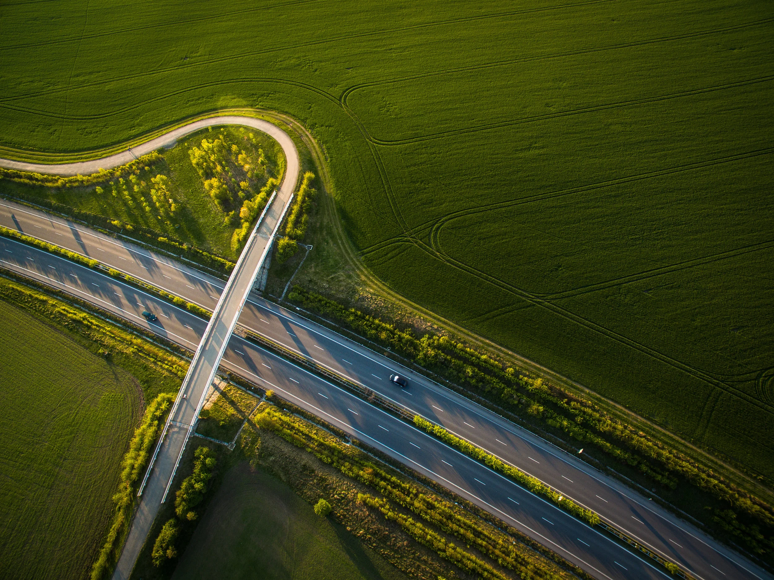 Aerialviewofahighwayamidfieldswithcarsonit(2).jpg