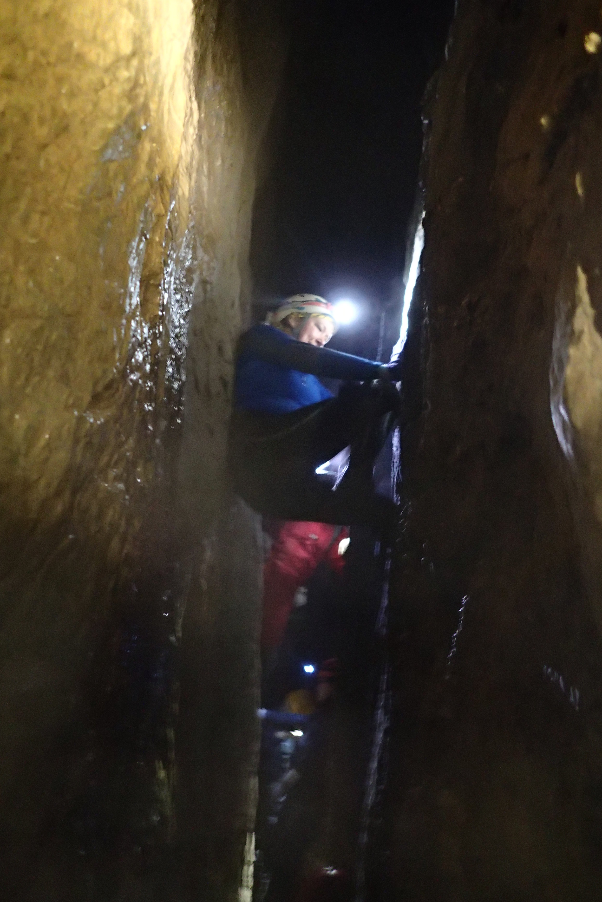 Chrissy leads the offwidth (unroped) about 30 vertical feet up to a ledge which led back down to the sump. Minds Blown.