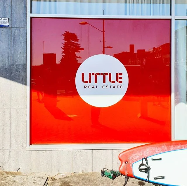Who said you can&rsquo;t work at the beach? 
Bentleigh Group loved installing these bright red window graphics for Little Real Estate. The sun was shining, the waves were crashing and the ice cream was melting 🏖️