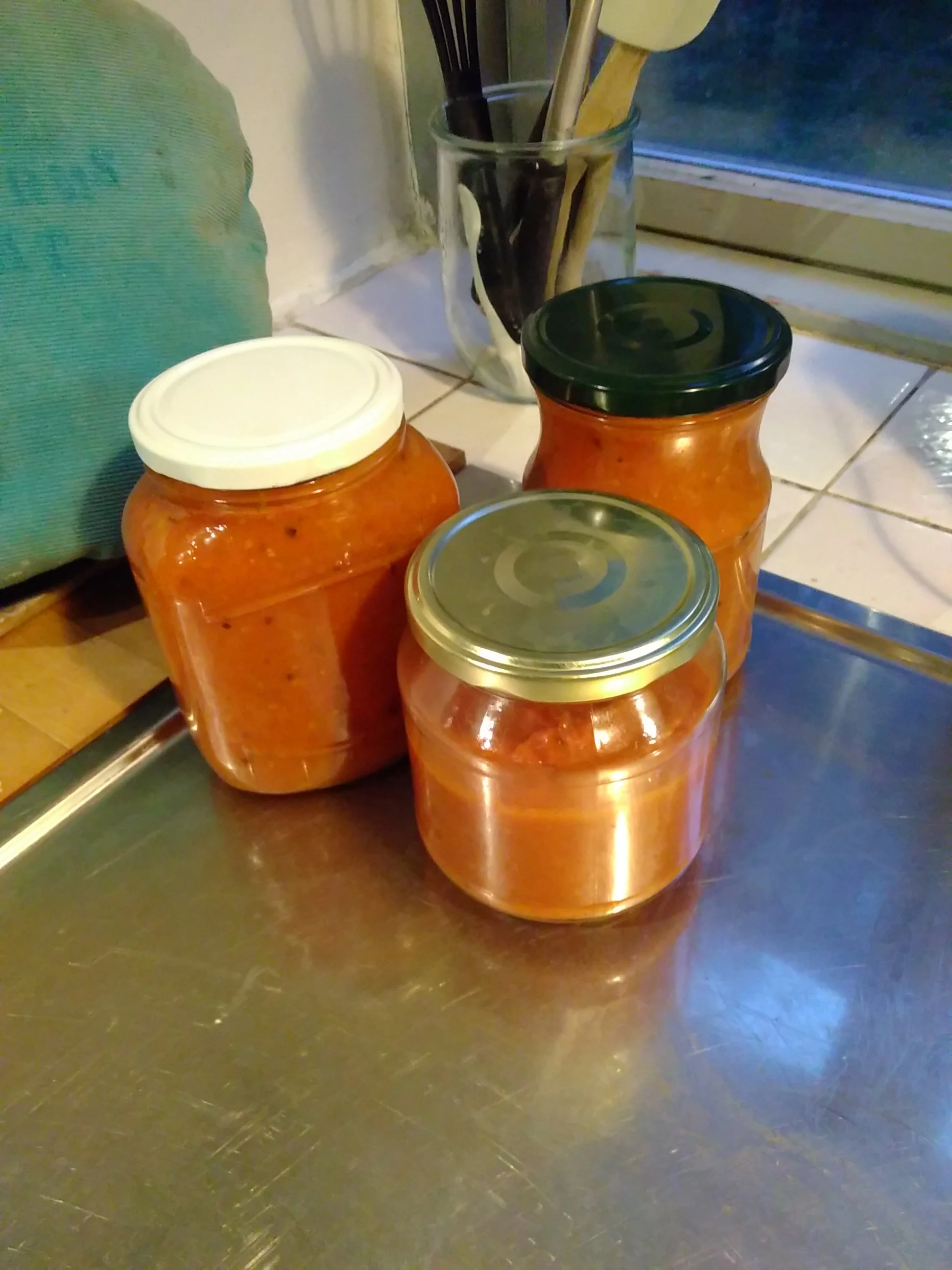 Madlavning er en vigtig del af selvforsyningslivet. Ressourcerne skal udnyttes, og høsten skal konserveres. Her ses tre glas tomatsovs, jeg lavede forleden af 2,5 kg af havens tomater.