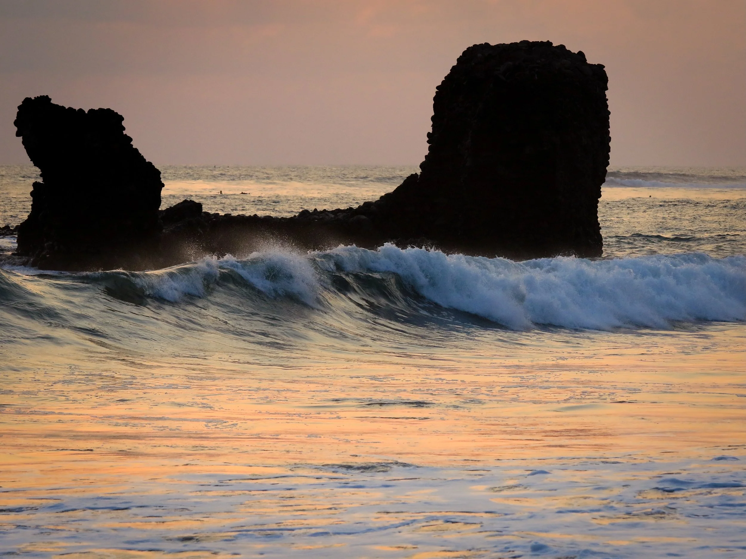 Waves crashing against the rocky coastline at El Tunco.jpg