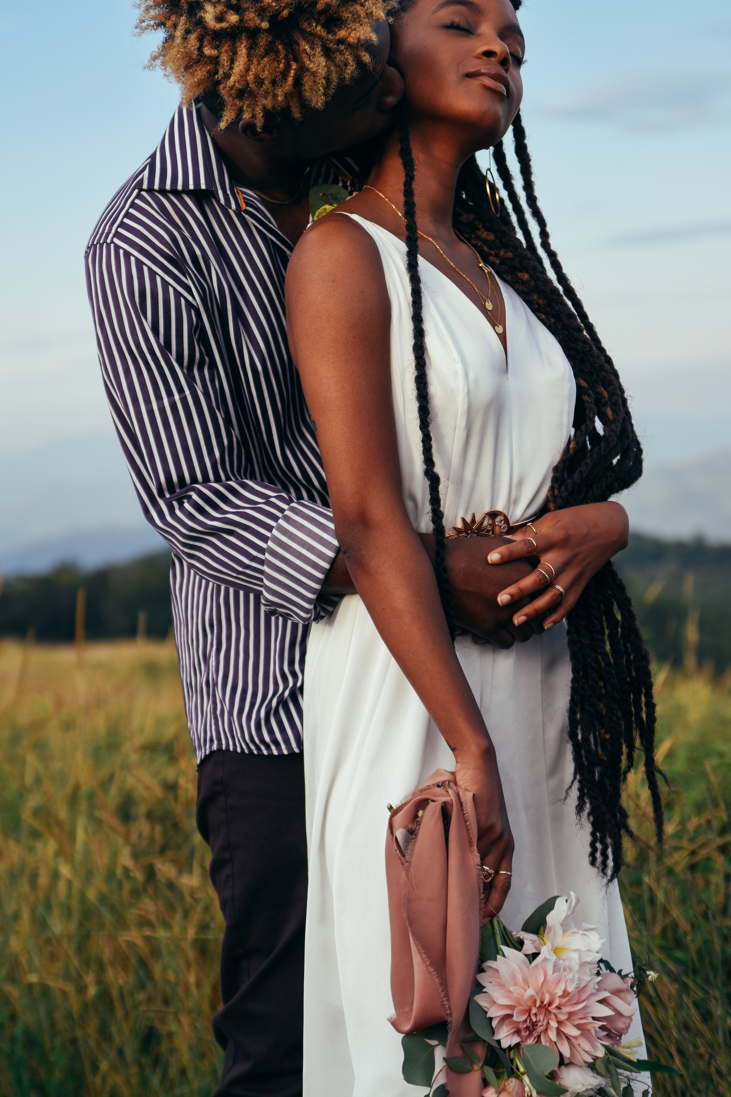  Close-up of an eloping couple as he hugs her from behind with the mountains the Blue Ridge Mountains in the background  