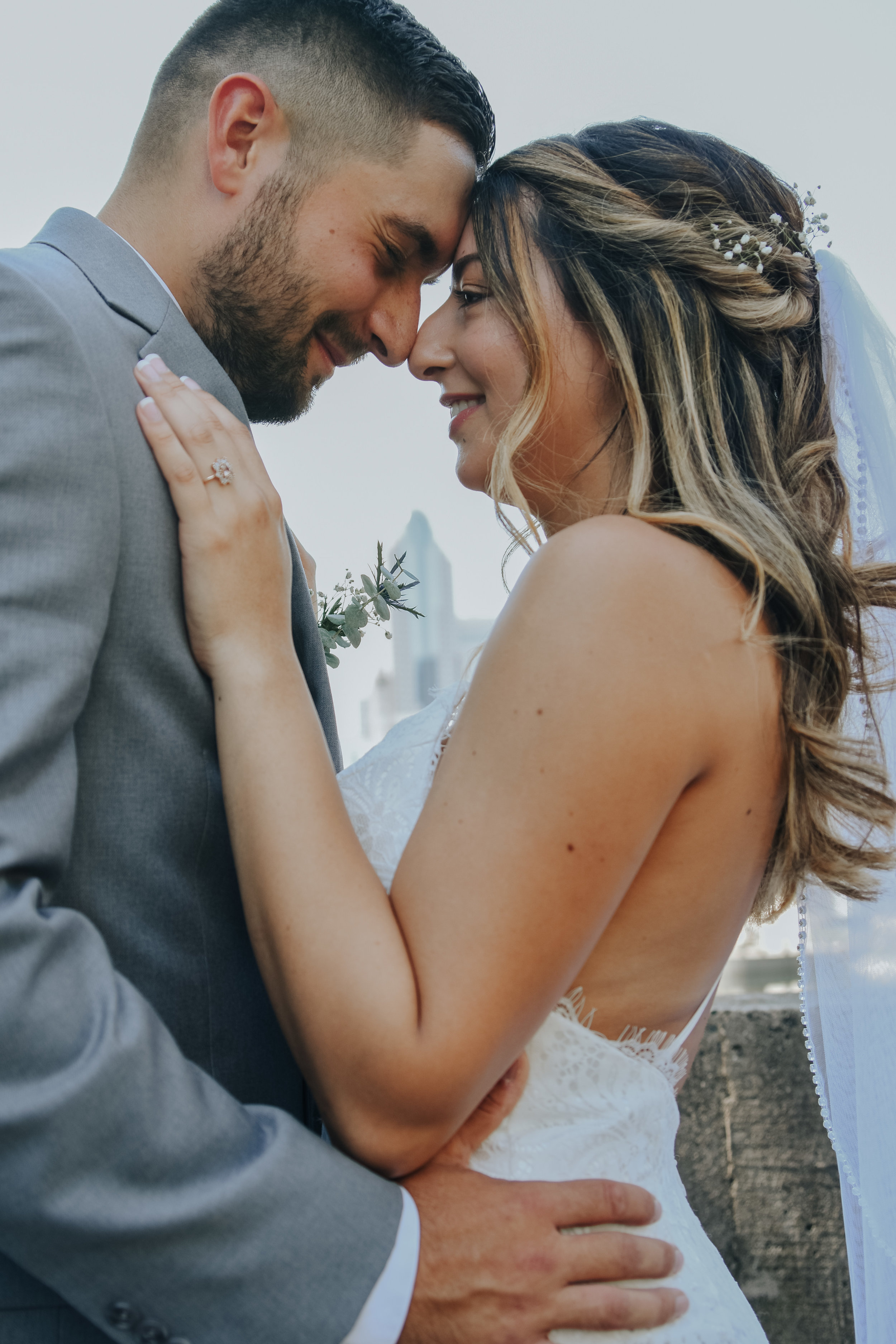  A picture of a couple embracing after their elopement, romantically holding each other close as they touch foreheads, as the bride’s hand rests on her partner’s shoulder, showing her new wedding ring Charlotte, NC courthouse elopement 