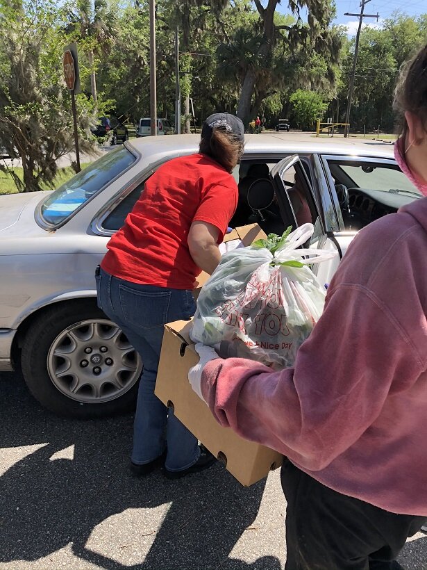 BEAM Volunteer loads a client’s car with groceries during the Finegan Mobile Food Pantry last week.