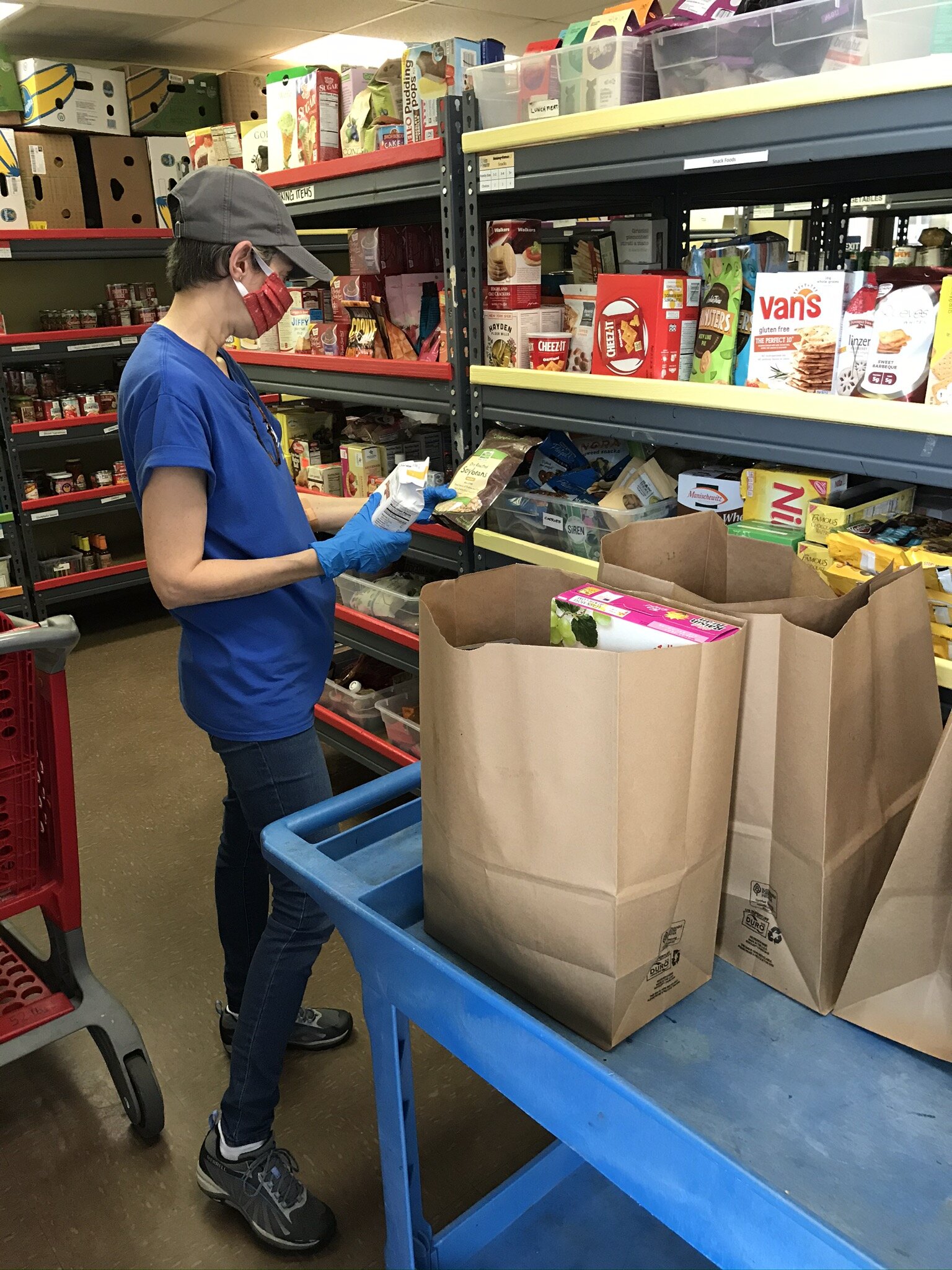 BEAM volunteer, Cindy, packs groceries on behalf of a food pantry client. BEAM’s food pantry appointments remain fully booked for the next few weeks.