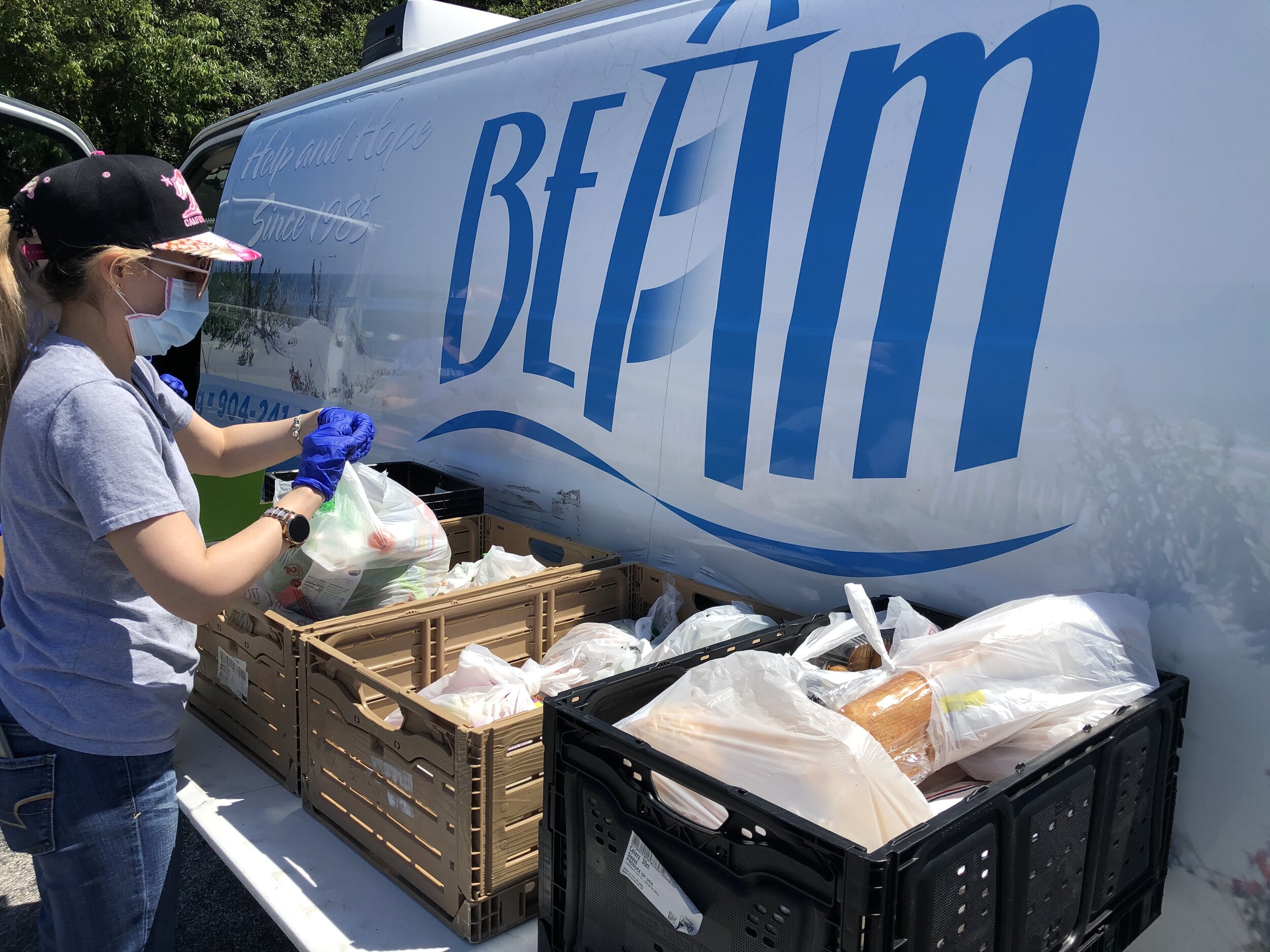 Milena, a BEAM staff member, sorts produce in preparation for families coming to pick up lunch from Joseph A. Finegan Elementary School.