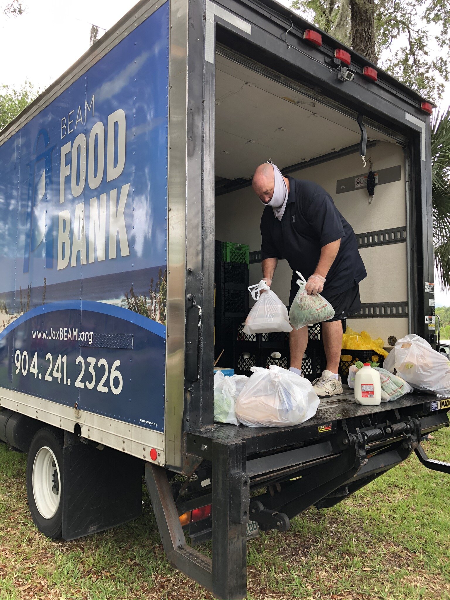A Volunteer unloads groceries from the BEAM Food Bank Truck during Oak Harbour Baptist Church’ s Mobile Food Distribution.