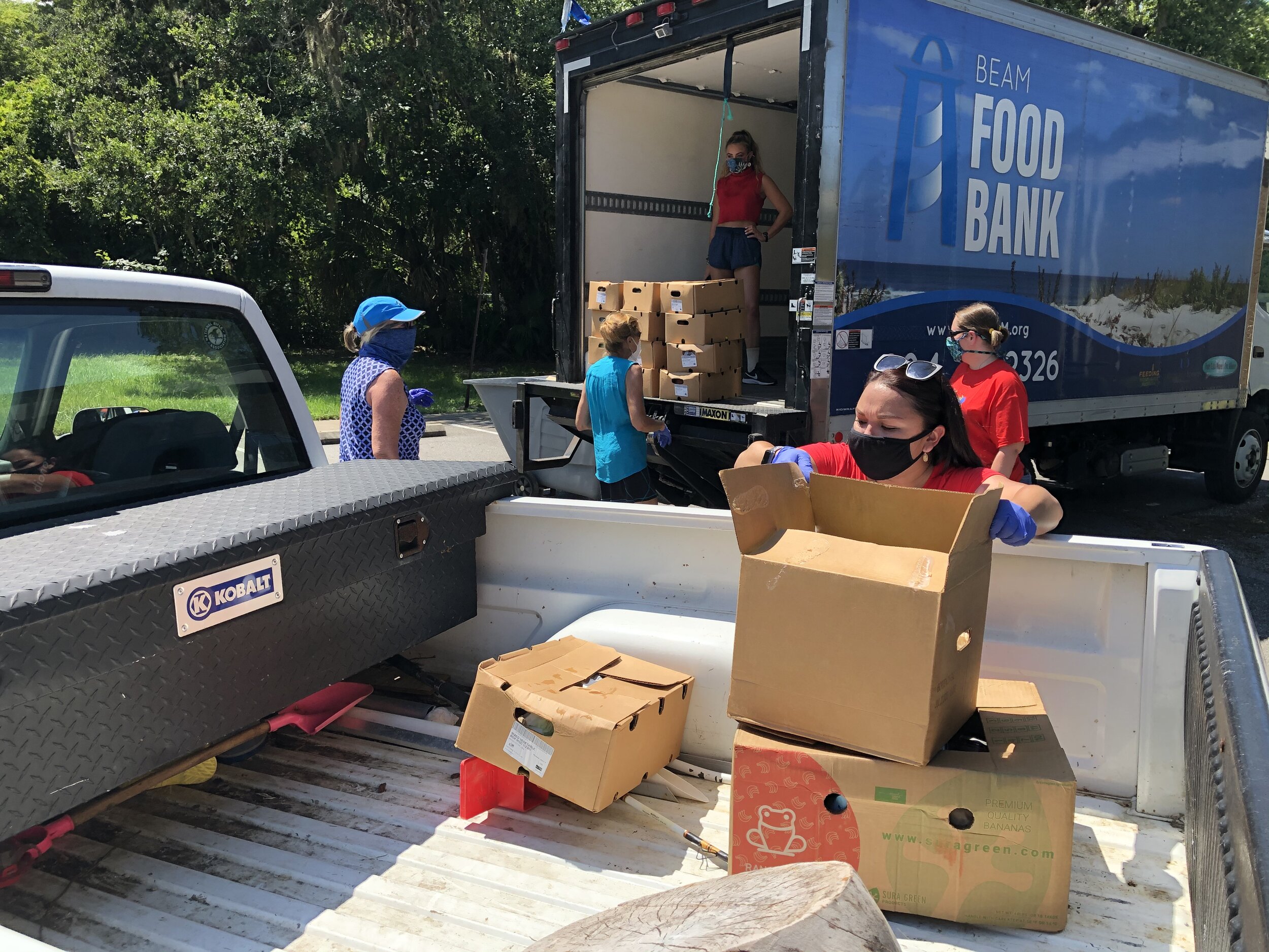 BEAM Volunteers load food onto the back of a client’s pickup truck during the Mobile food distribution at Finegan Elementary.