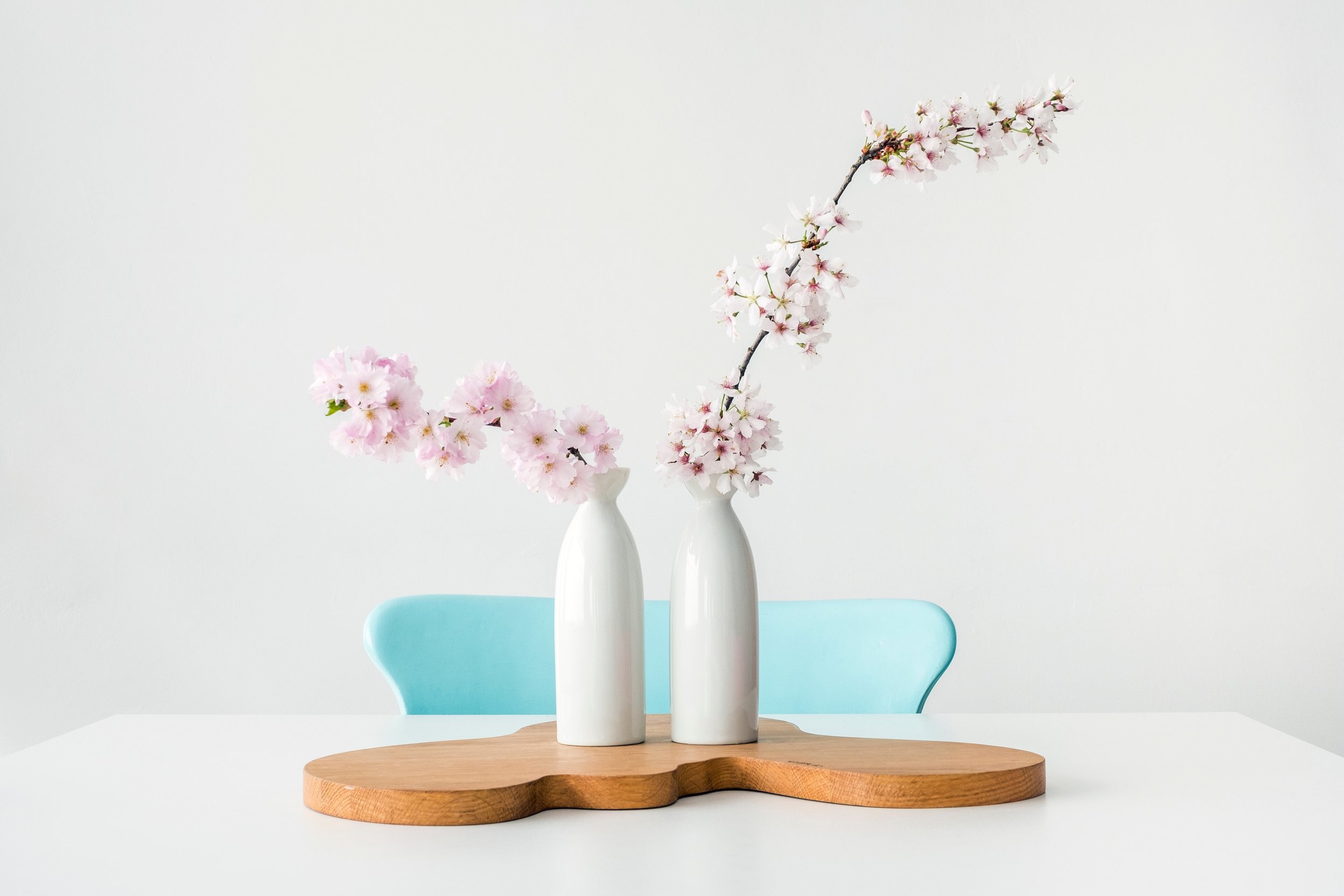 teal chairs tiny pink flowers in vase on table.jpg