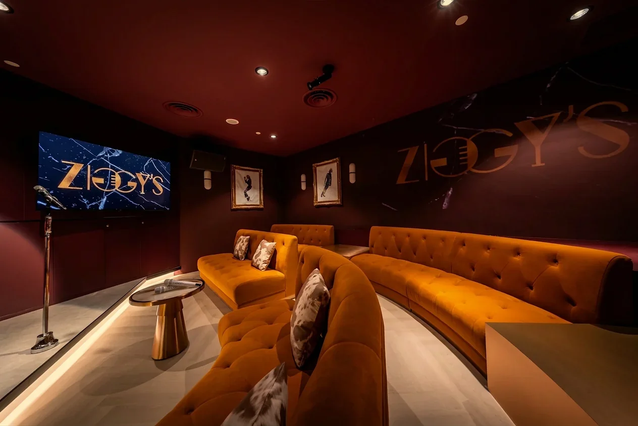 ZIGGY'S VIP karaoke room with large screen and amber velvet seating