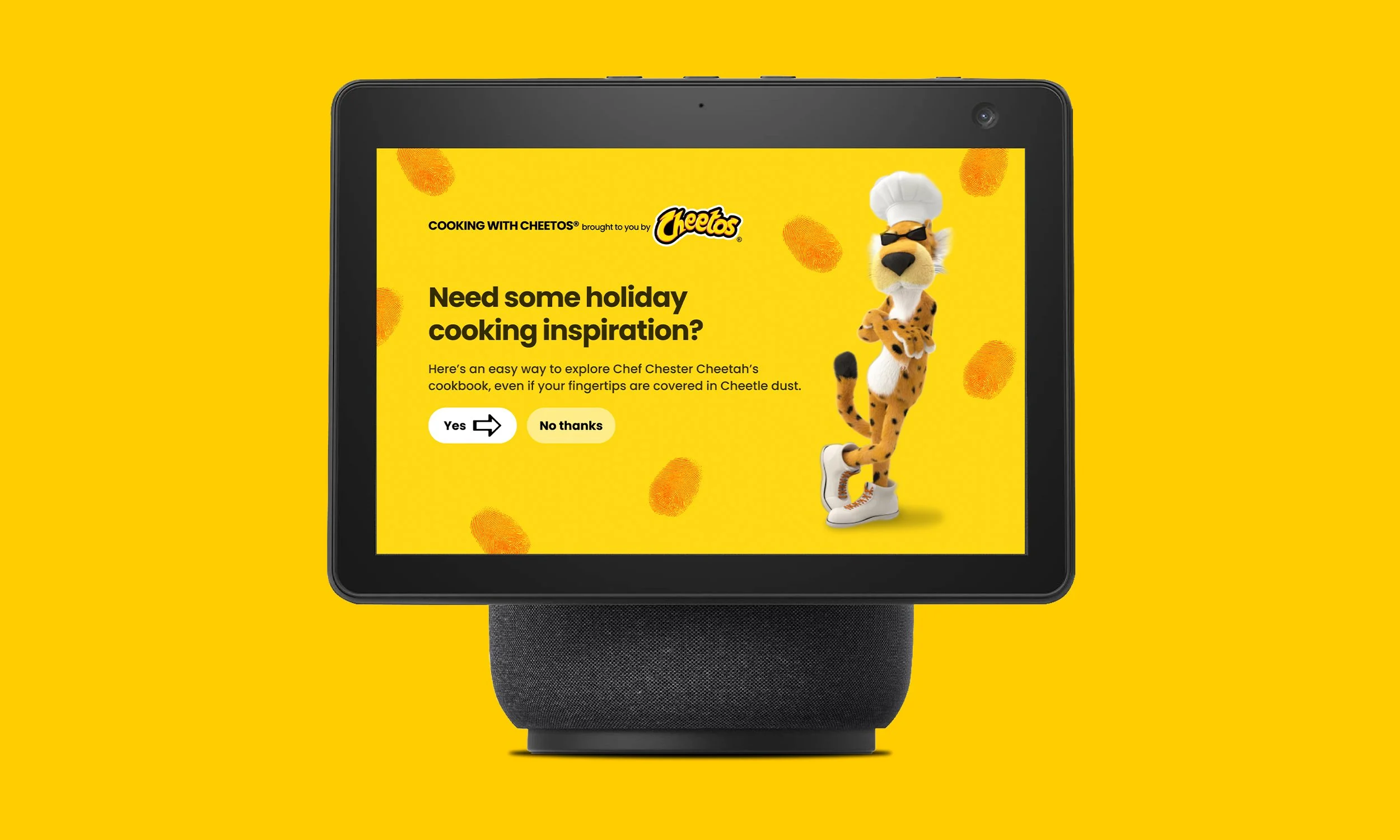 A smart display with a yellow background screen featuring Cheetos branding and an animated chef Chester Cheetah dressed as a chef with sunglasses, standing with arms crossed. The message promotes holiday cooking inspiration and has options to answer 'Yes' or 'No thanks'.