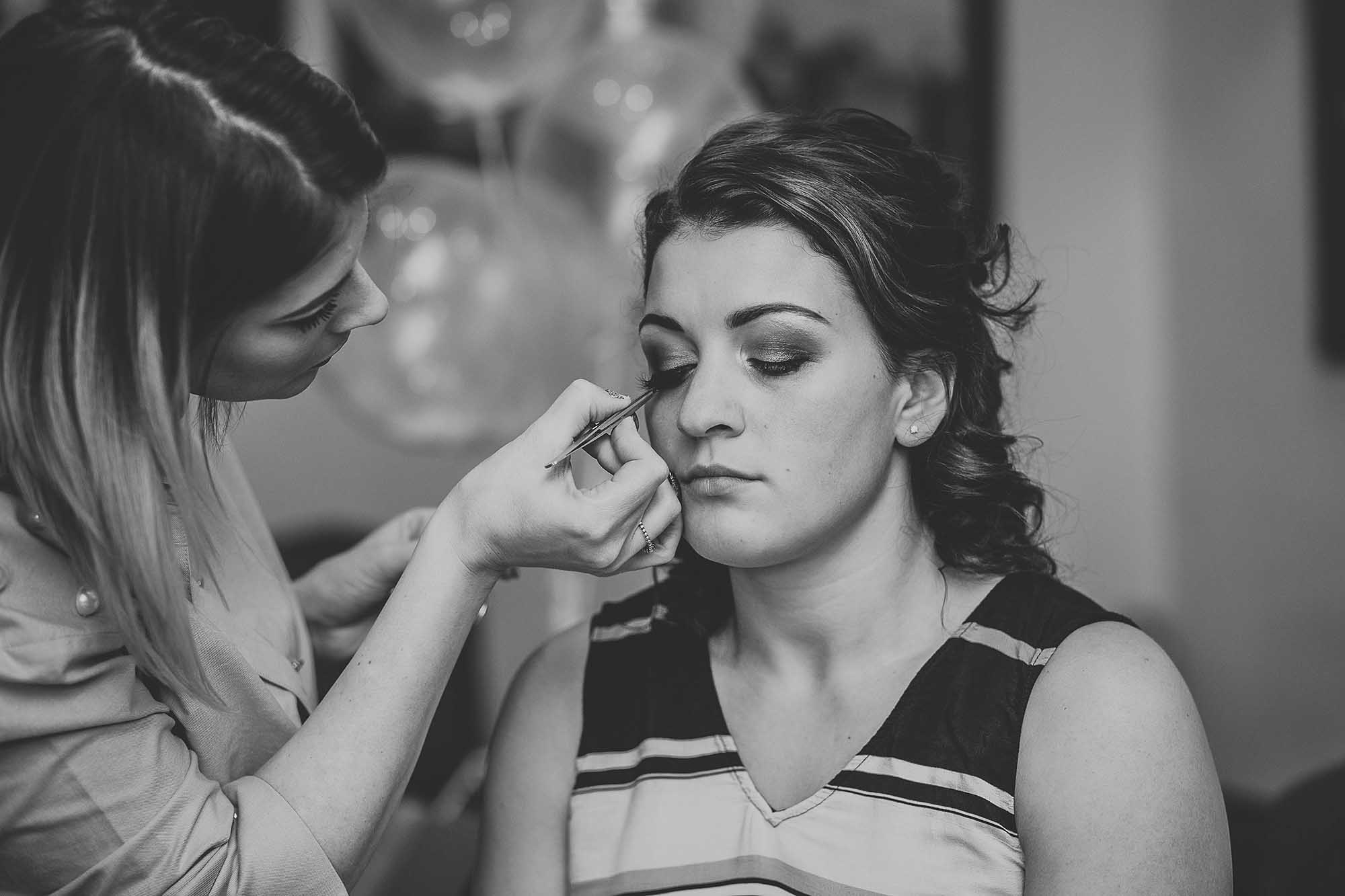 bridesmaid getting her makeup done at Holdsworth House