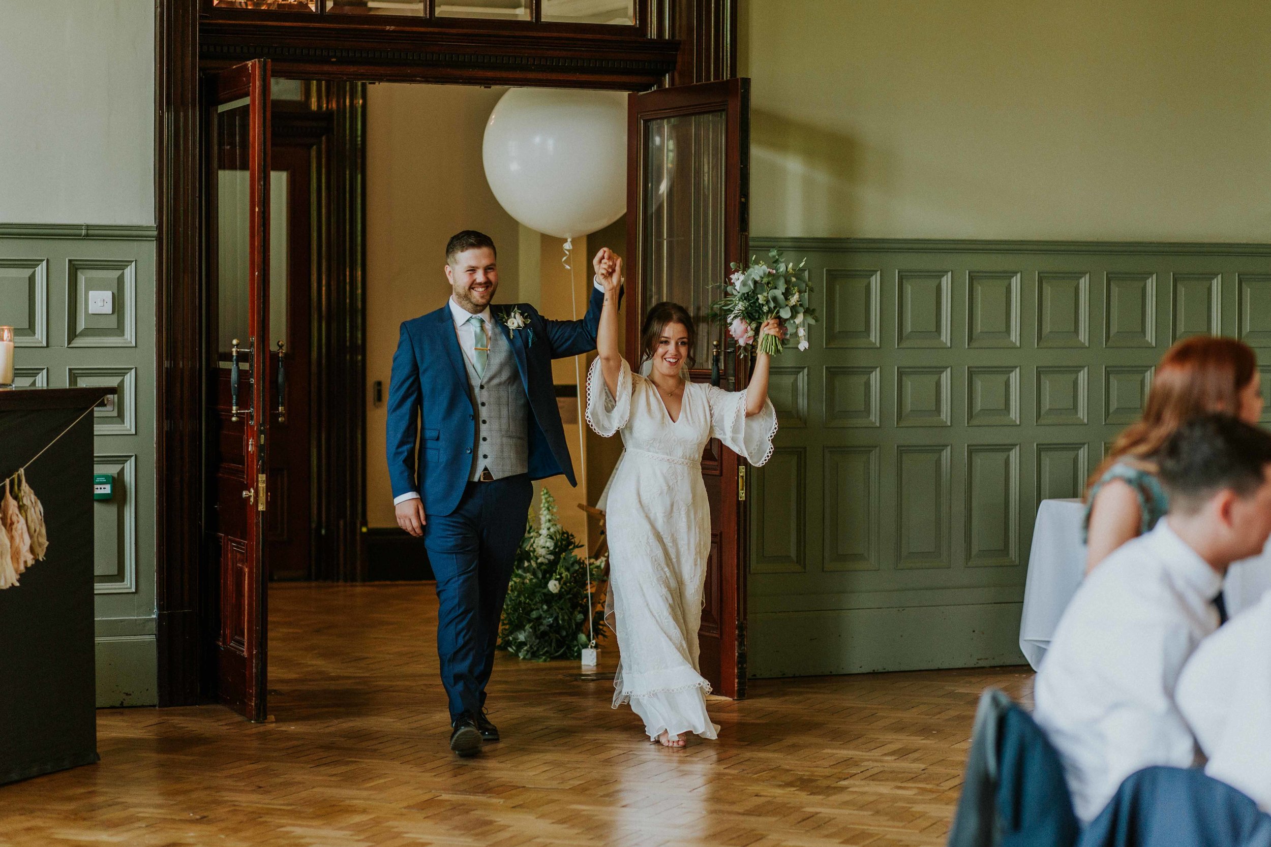 bride and groom walking into wedding venue at The Whitworth